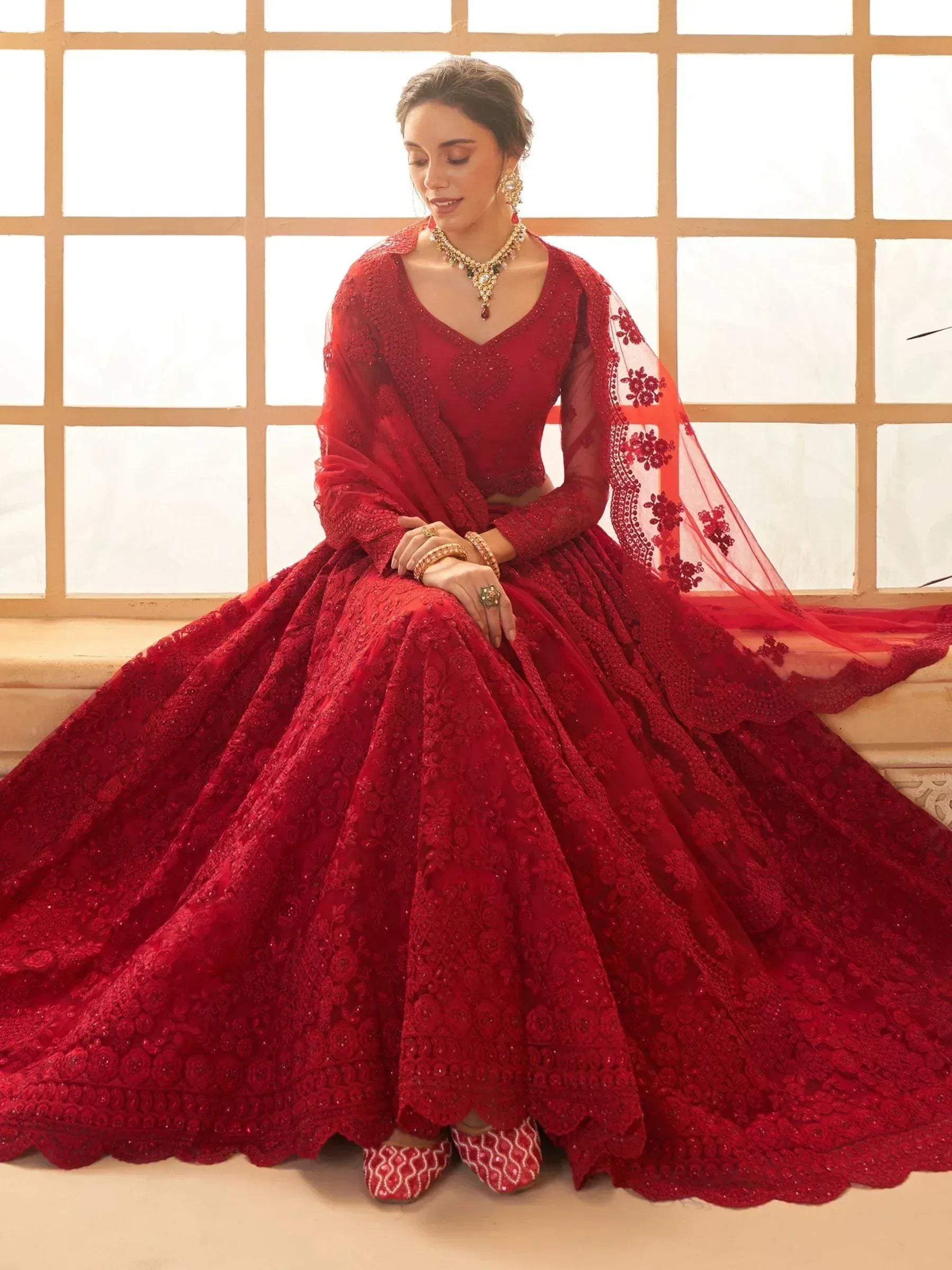 Red embroidered lehenga choli with sheer dupatta, perfect for Indian weddings and festive occasions.