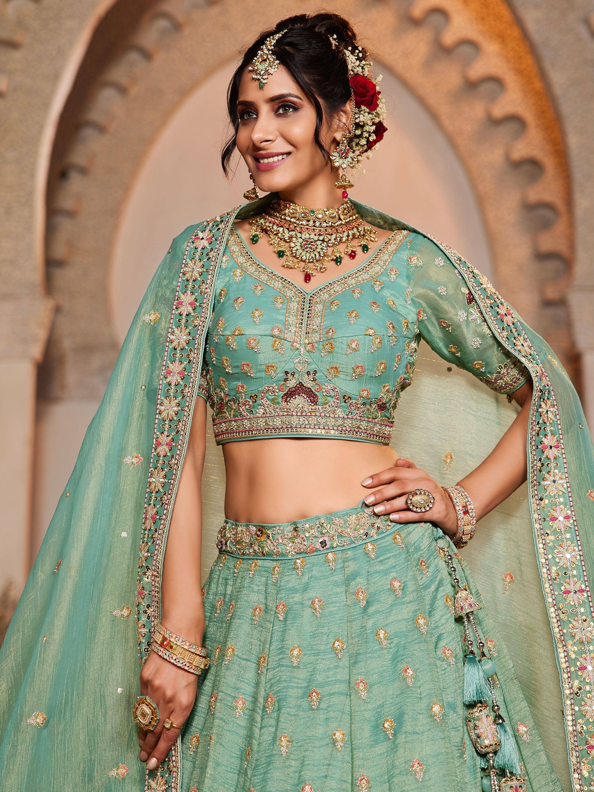 Mint green embroidered lehenga choli with heavy jewelry for Indian weddings