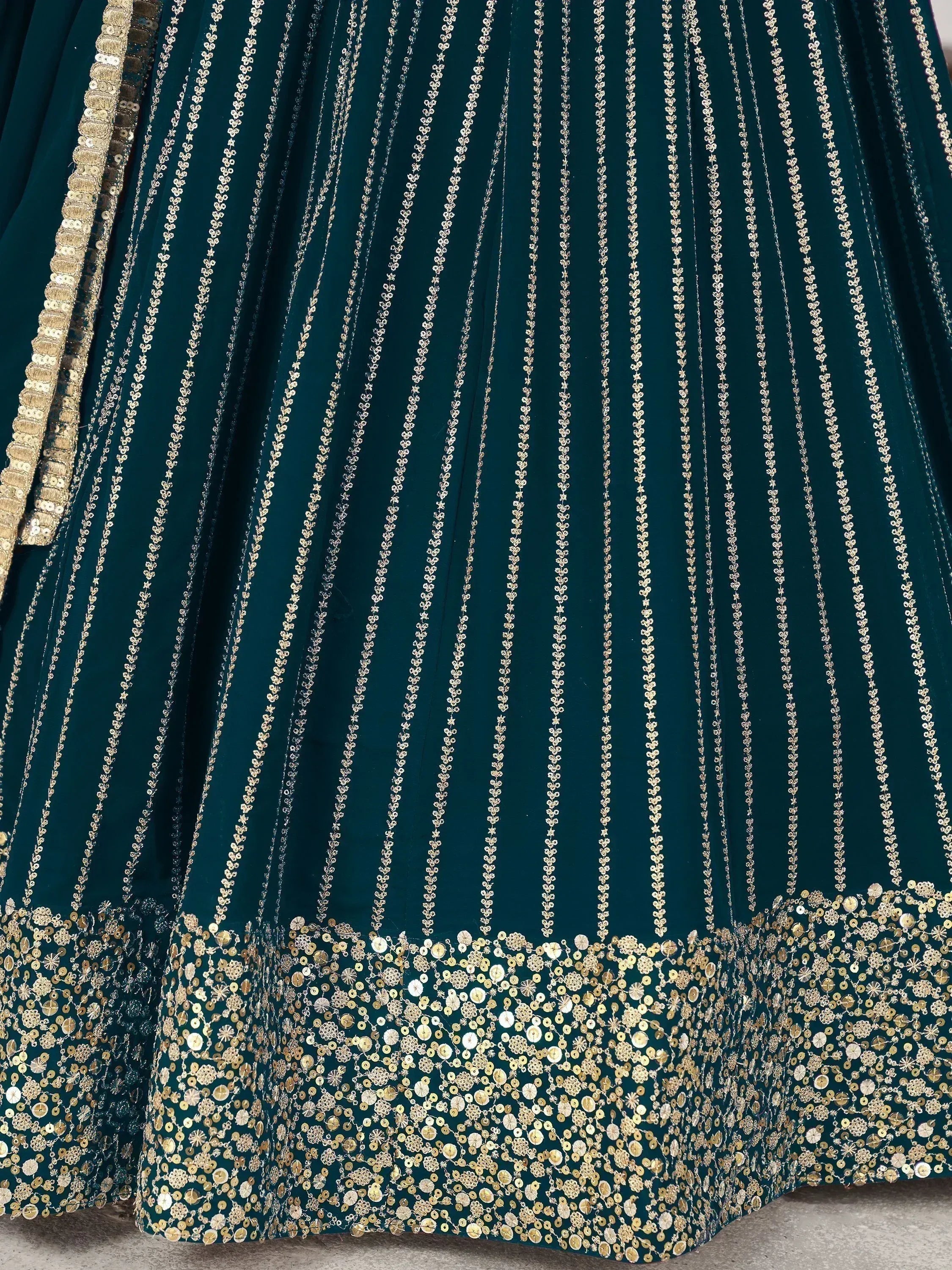 Emerald green lehenga with gold sequin embroidery and floral detailing, perfect for Indian ethnic wear.