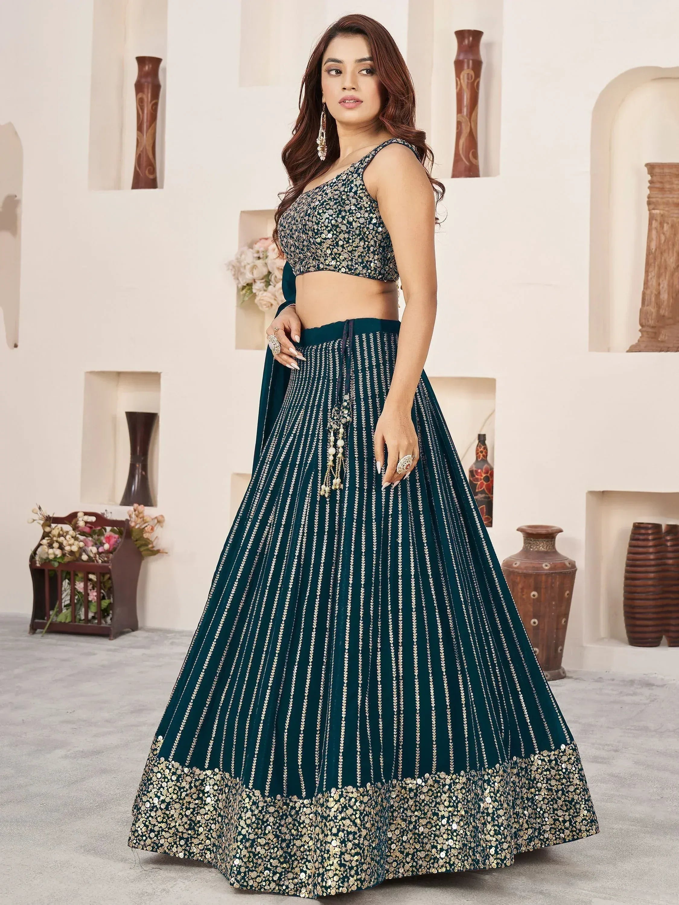 Elegant teal lehenga choli with gold embroidery and sequin detailing for festive occasions