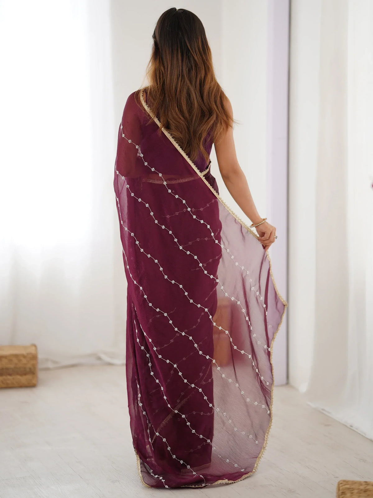 Woman in maroon embroidered saree with gold border, showcasing Indian ethnic wear