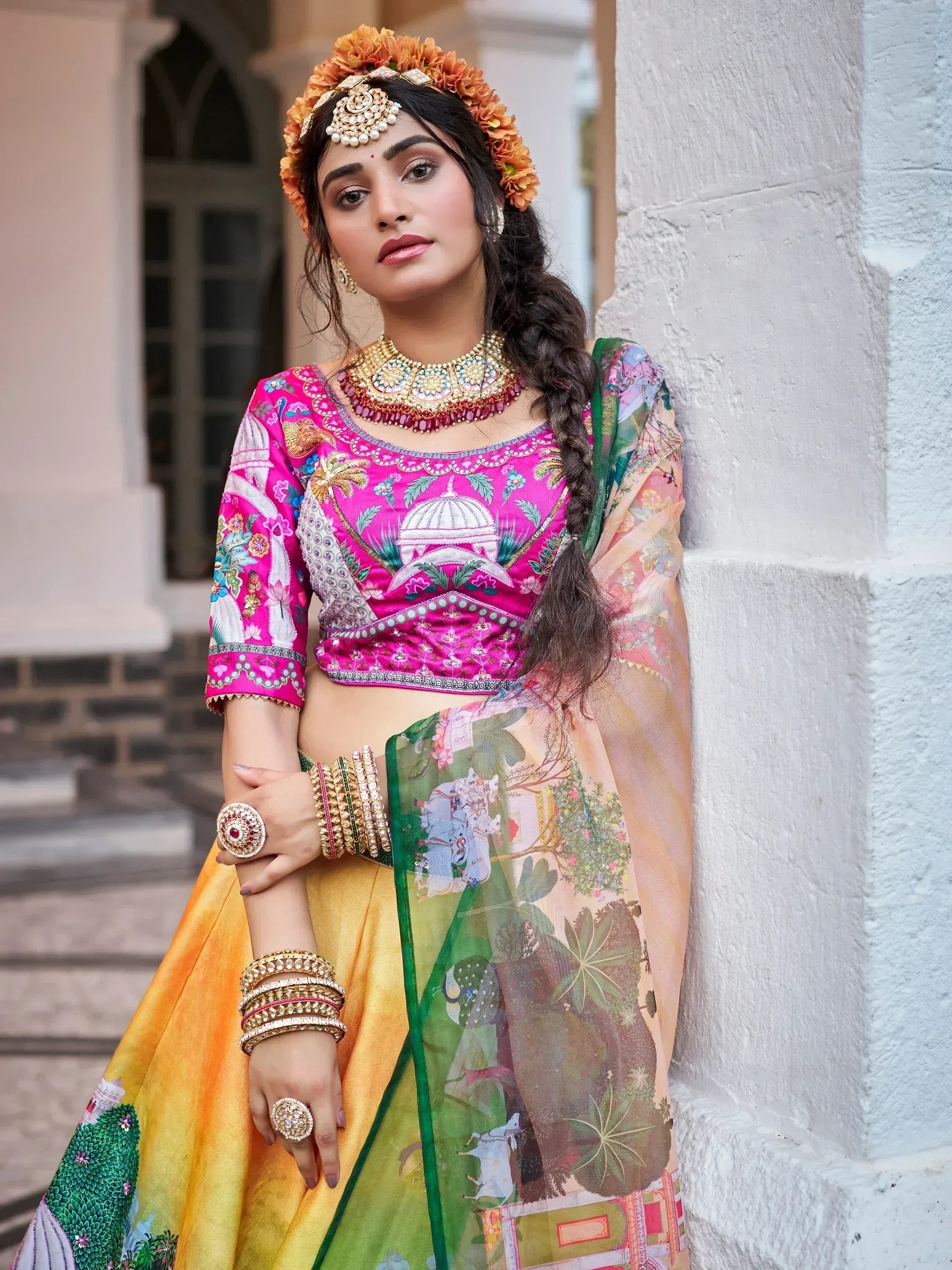 Woman in vibrant pink embroidered lehenga choli with floral dupatta, traditional Indian ethnic wear