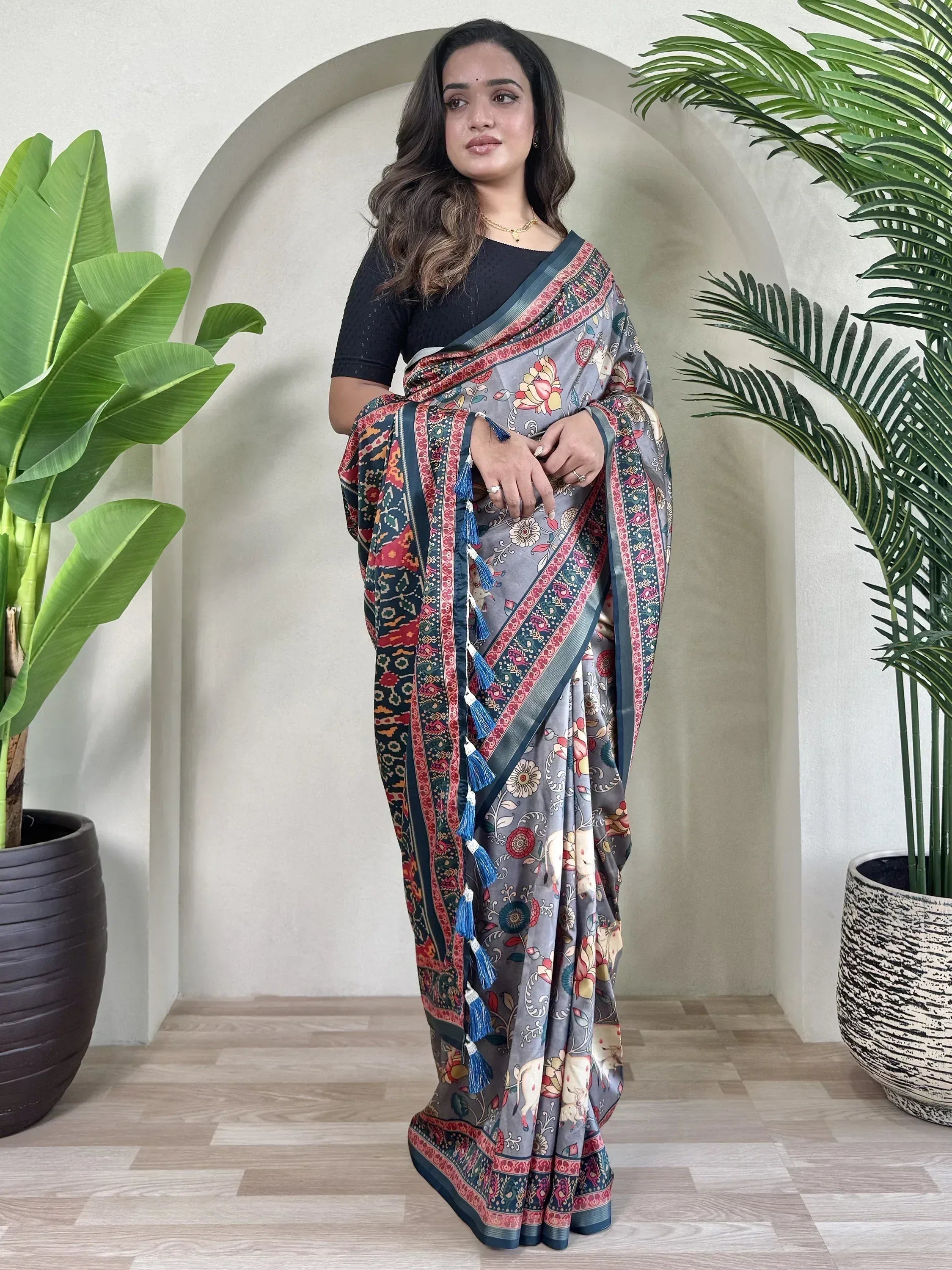 Woman wearing grey floral printed saree with blue tassels, ethnic Indian wear, stylish designer saree