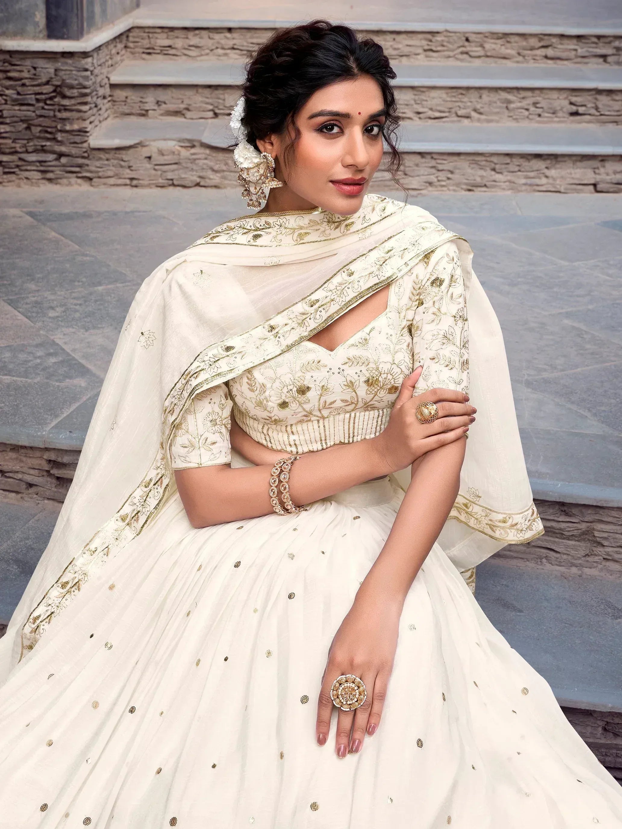 Elegant ivory lehenga choli with gold floral embroidery, perfect for Indian weddings and festive occasions.