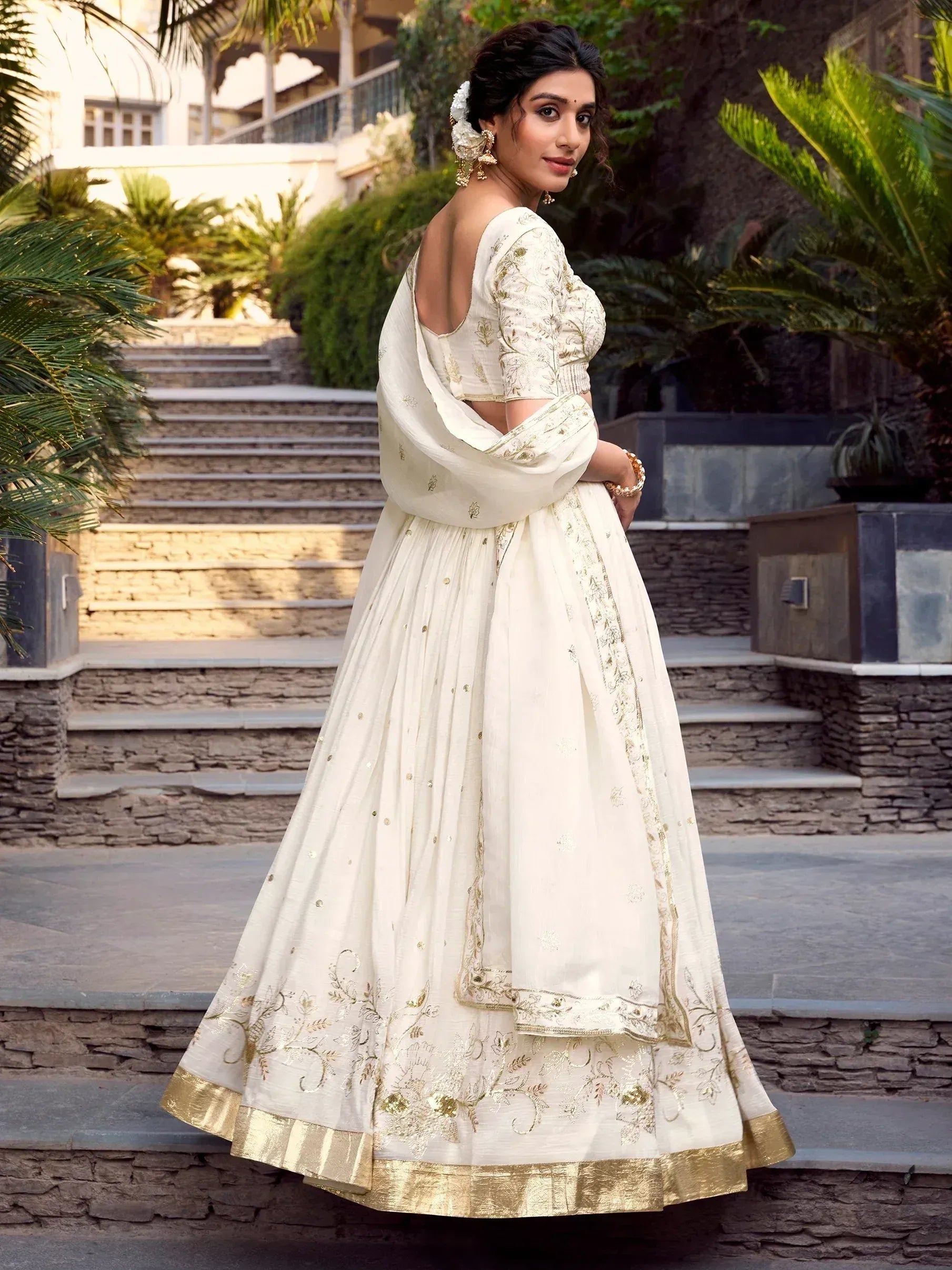 Elegant ivory lehenga choli with gold embroidery, perfect for Indian weddings and festive occasions.
