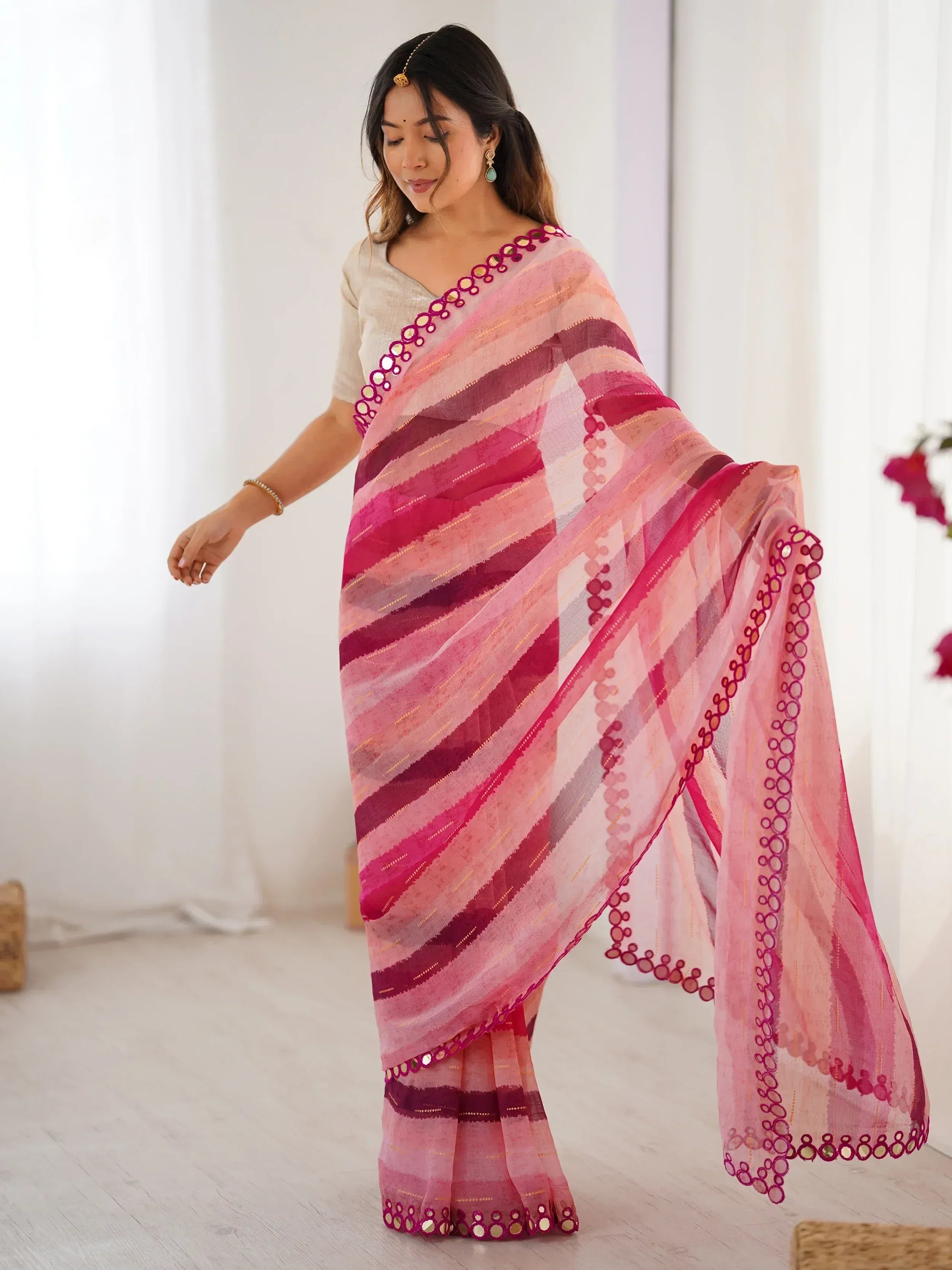 Woman wearing pink striped saree with mirror work, ethnic Indian wear for festive occasions