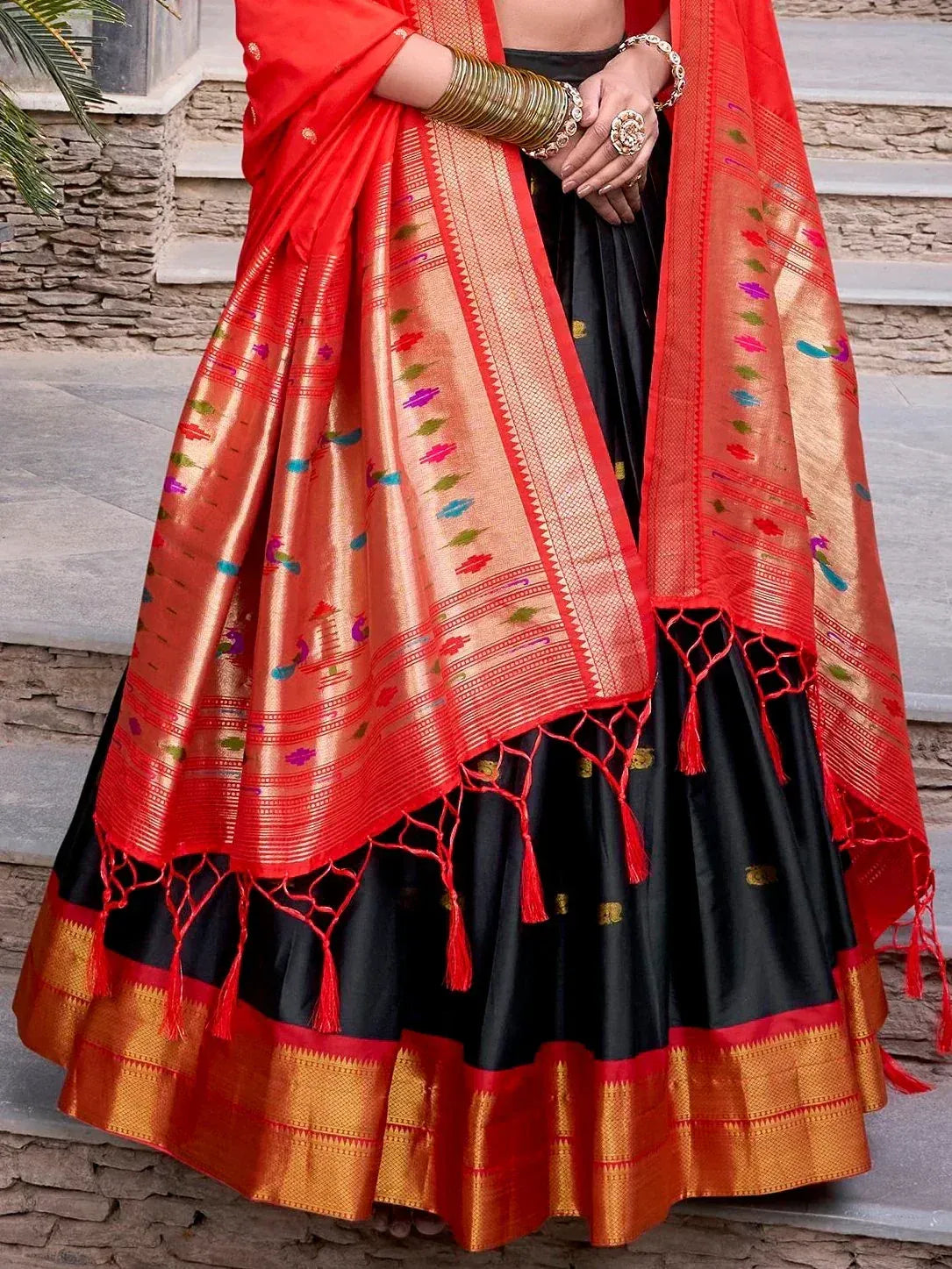 Black and red designer lehenga choli with colorful woven motifs and tassels, perfect for Indian ethnic wear