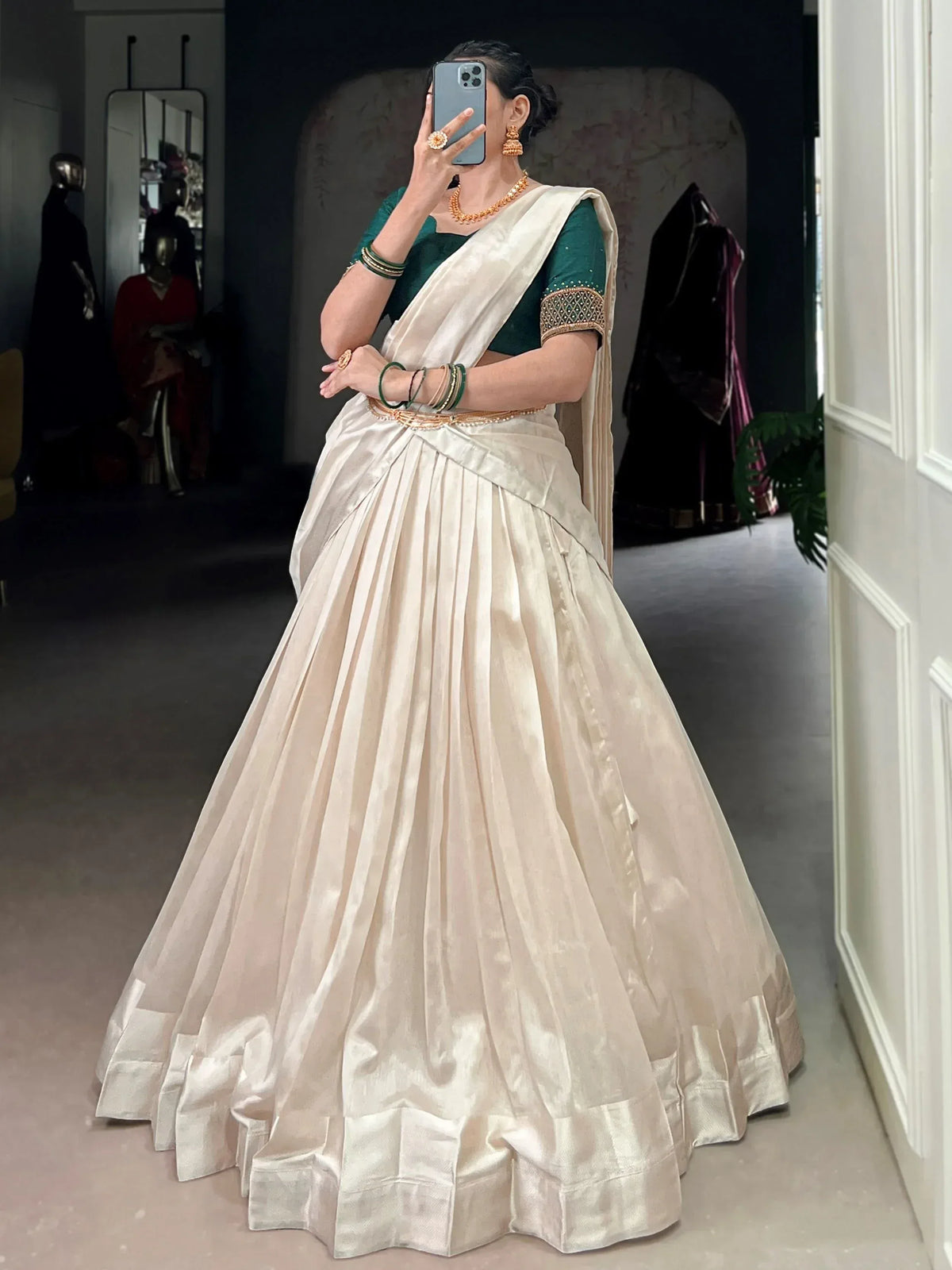 Elegant ivory pleated lehenga with green blouse, perfect for Indian ethnic wear and festive occasions.