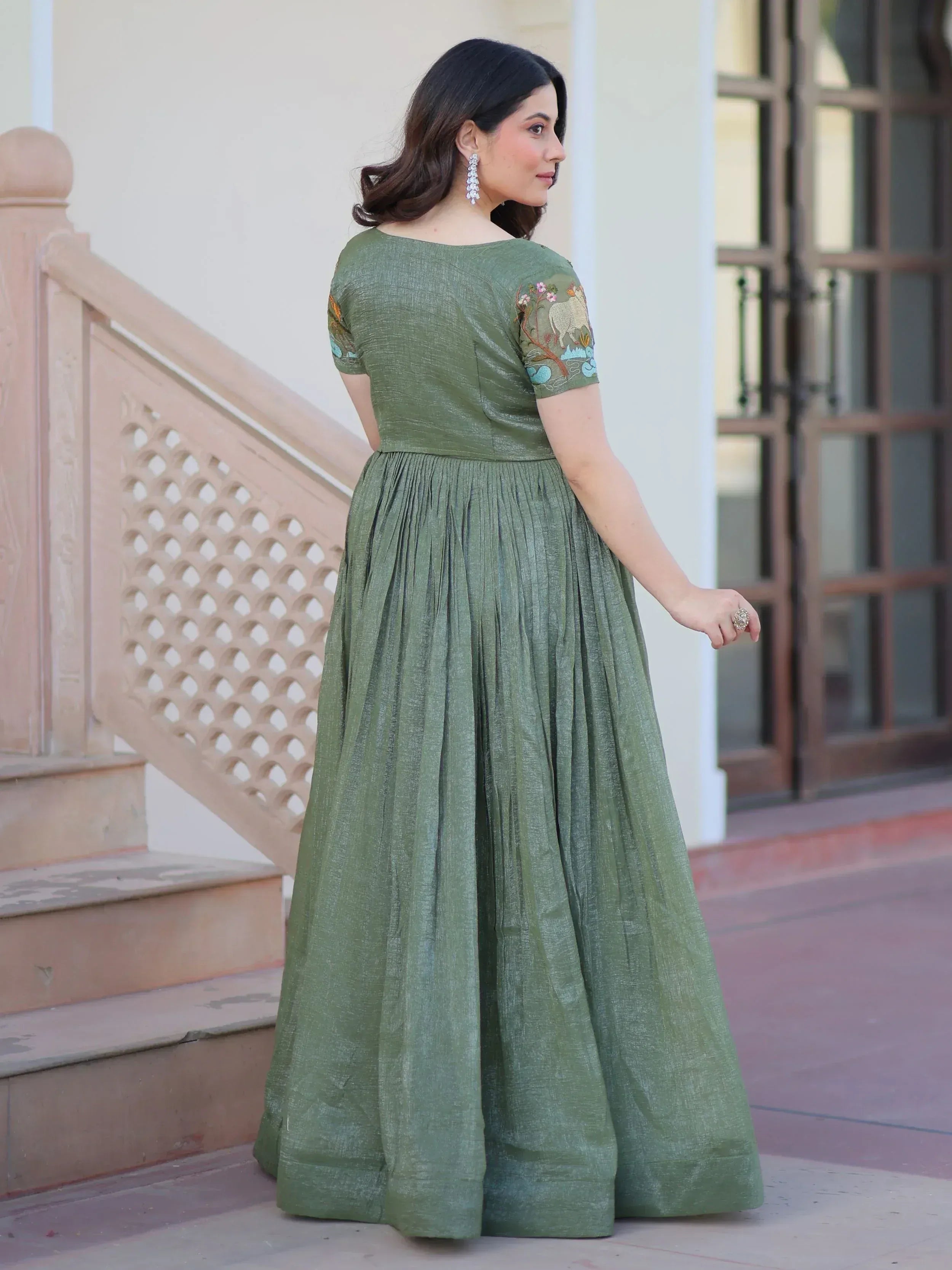 Olive green ethnic gown with floral and animal embroidery, pleated skirt, perfect for Indian occasions.