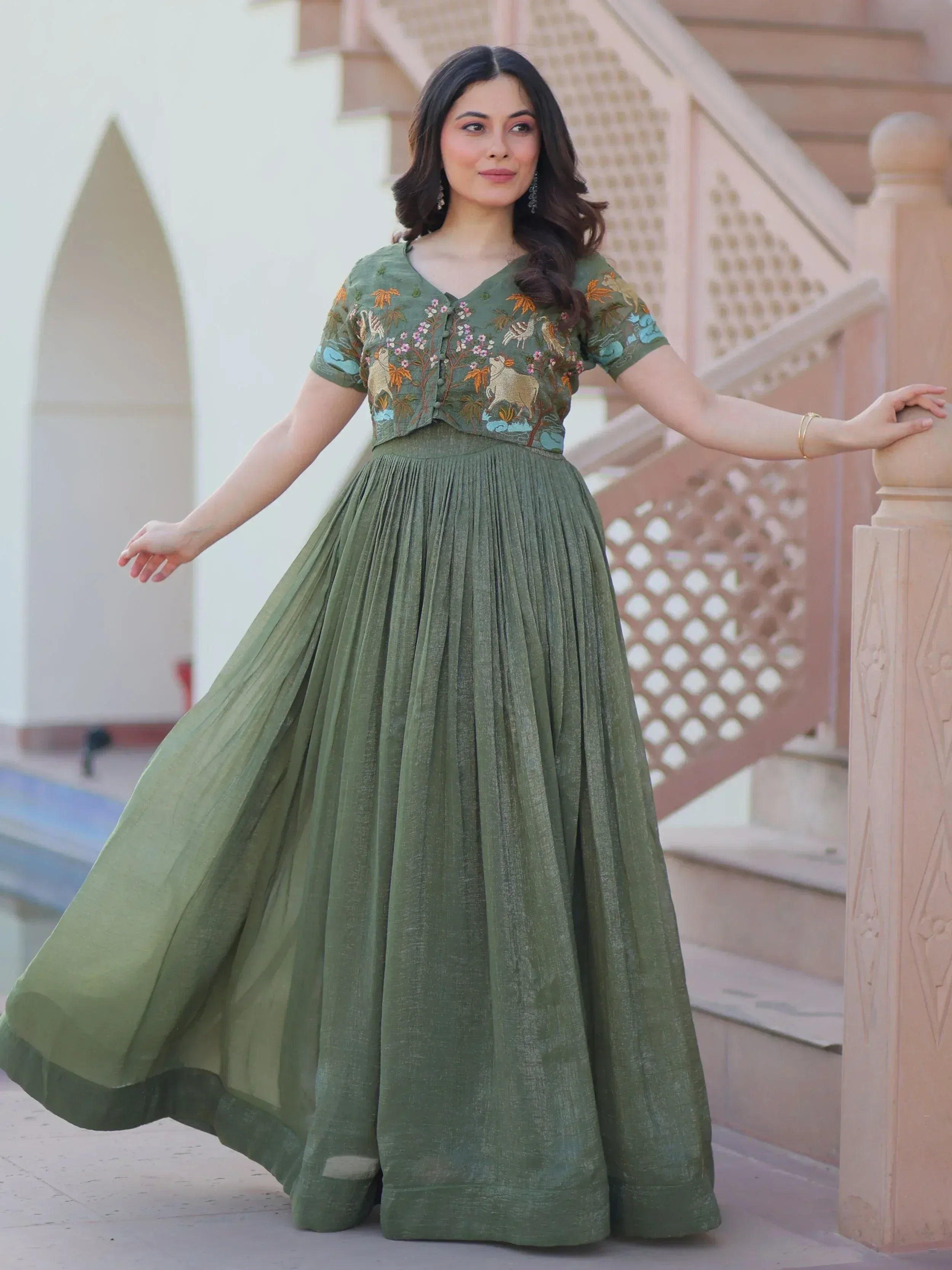 Olive green ethnic gown with floral and animal embroidery, pleated skirt, perfect for Indian occasions.