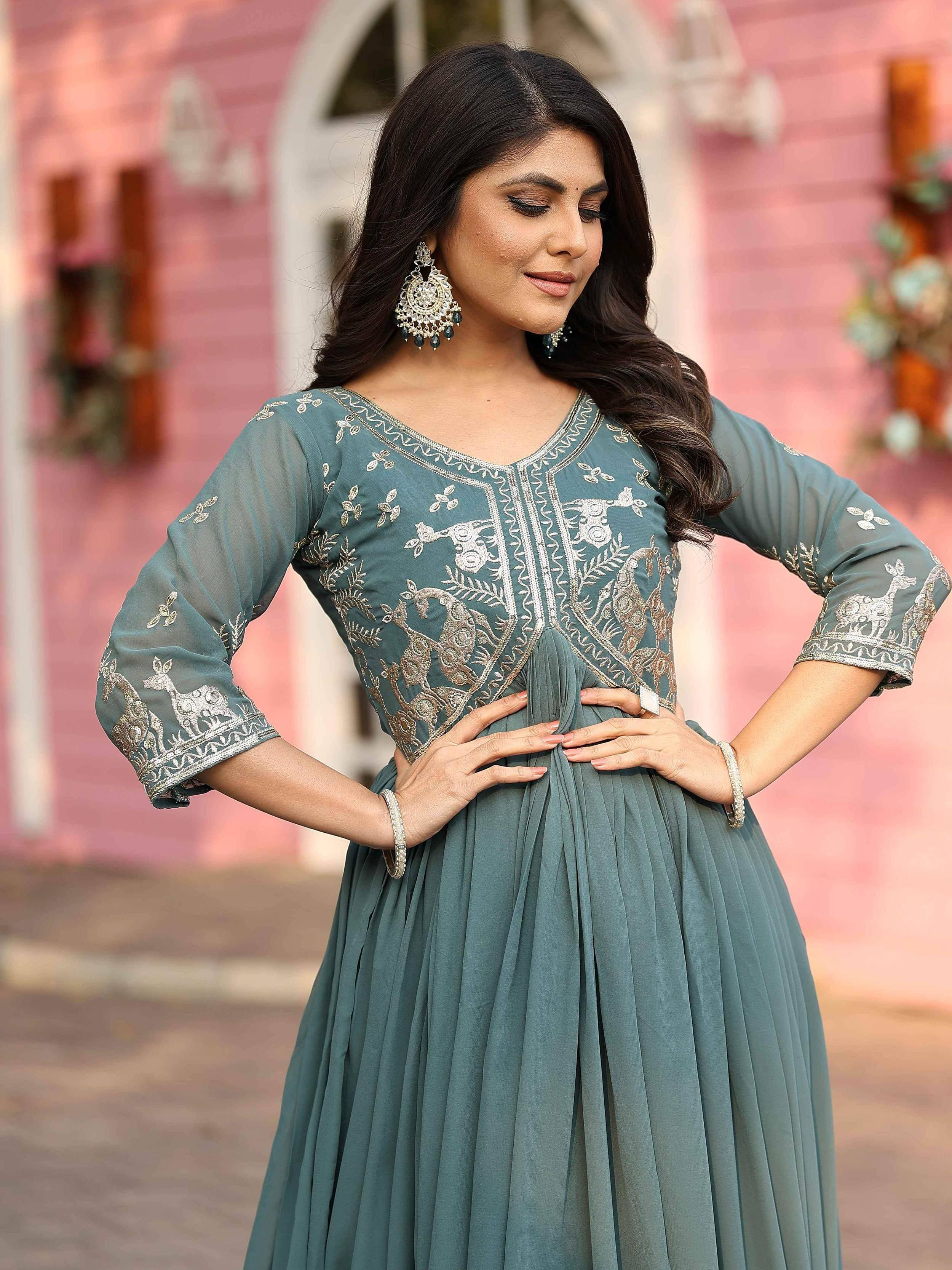 Woman in teal ethnic gown with deer embroidery, perfect for Indian occasions and festive wear.