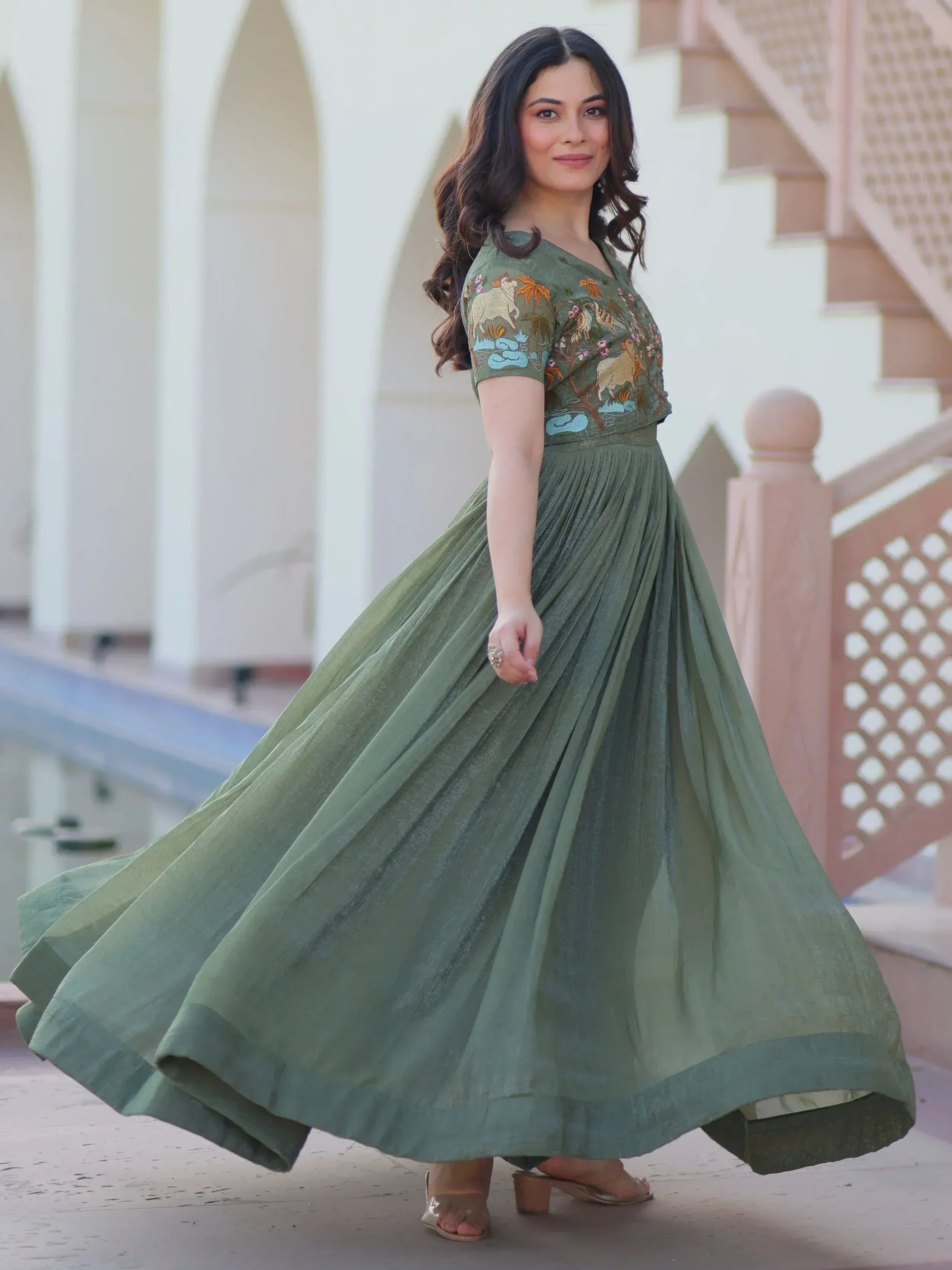 Woman in olive green ethnic gown with animal embroidery, pleated skirt, perfect for Indian occasions