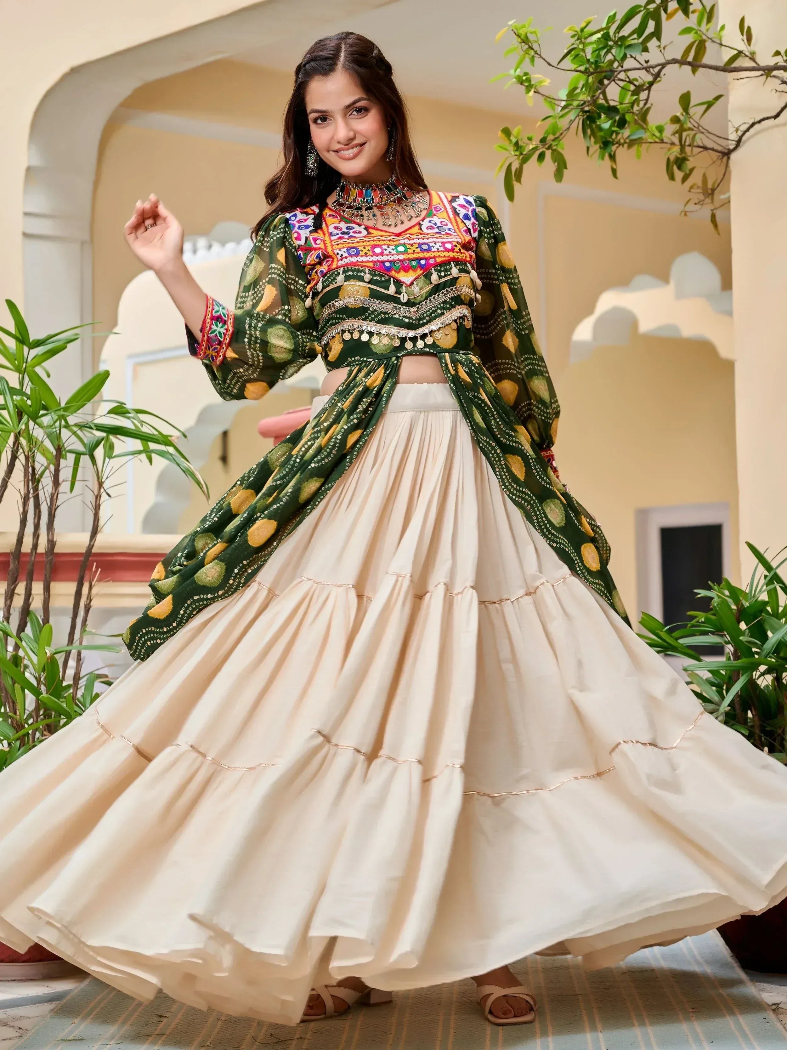 Woman in vibrant green embroidered crop top with cream pleated skirt, Indian ethnic wear