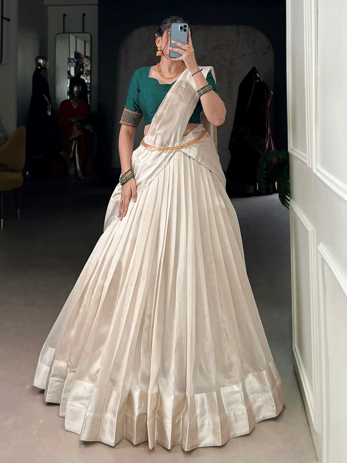 Woman in cream pleated lehenga with green blouse, ethnic Indian wear, mirror selfie