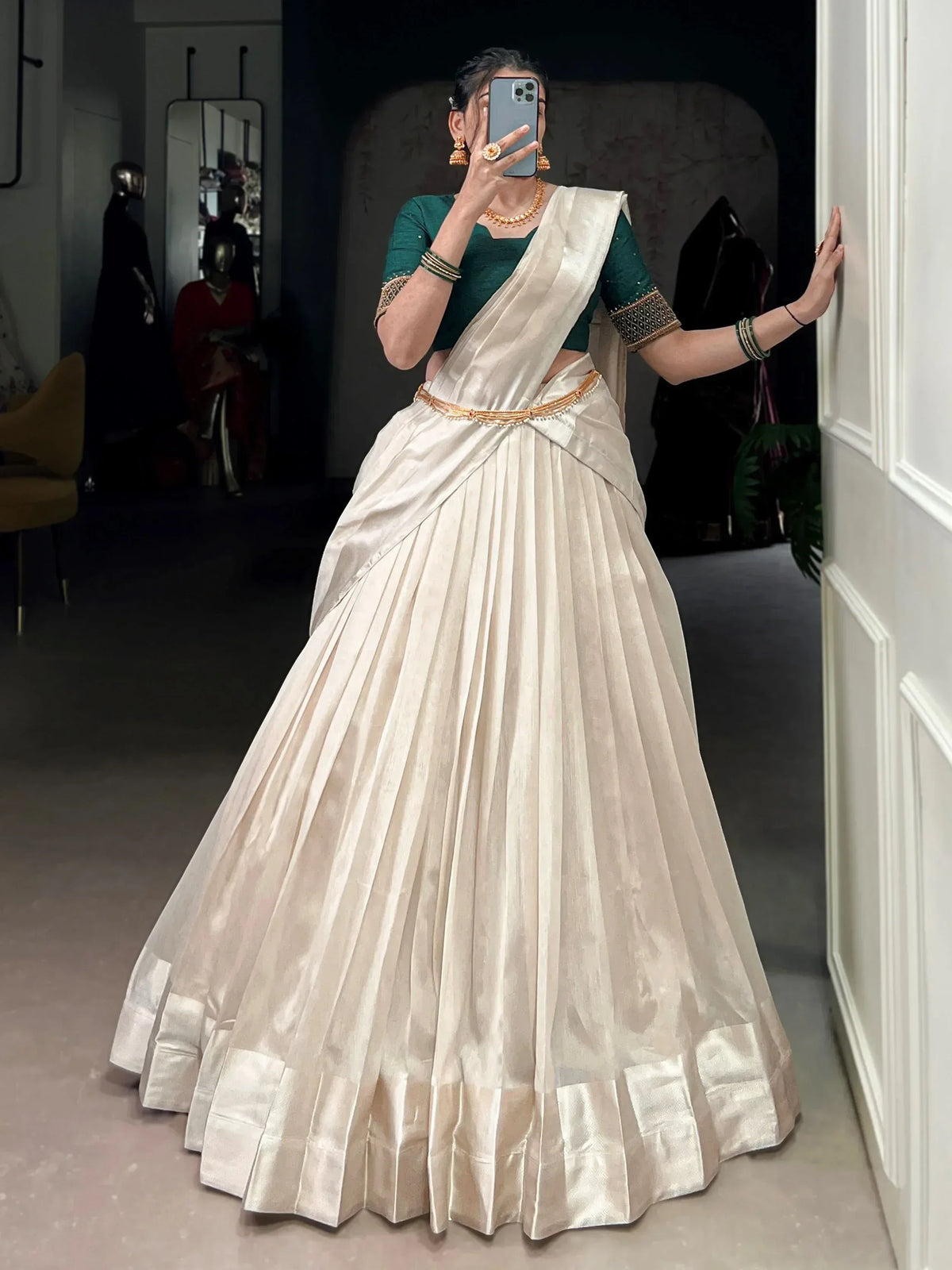 Elegant ivory pleated lehenga with green blouse, perfect for Indian ethnic wear and festive occasions.