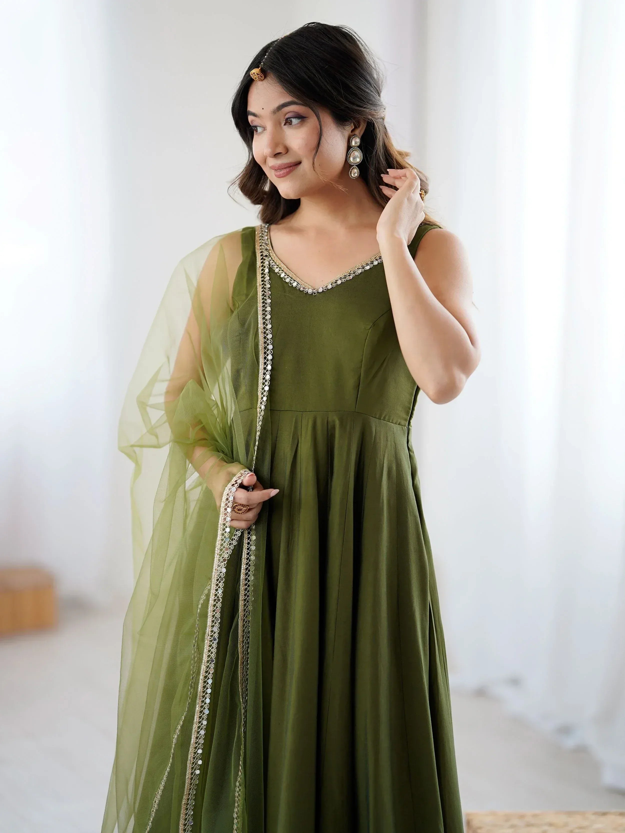 Olive green ethnic gown with gold embroidery and sheer dupatta, perfect for Indian occasions
