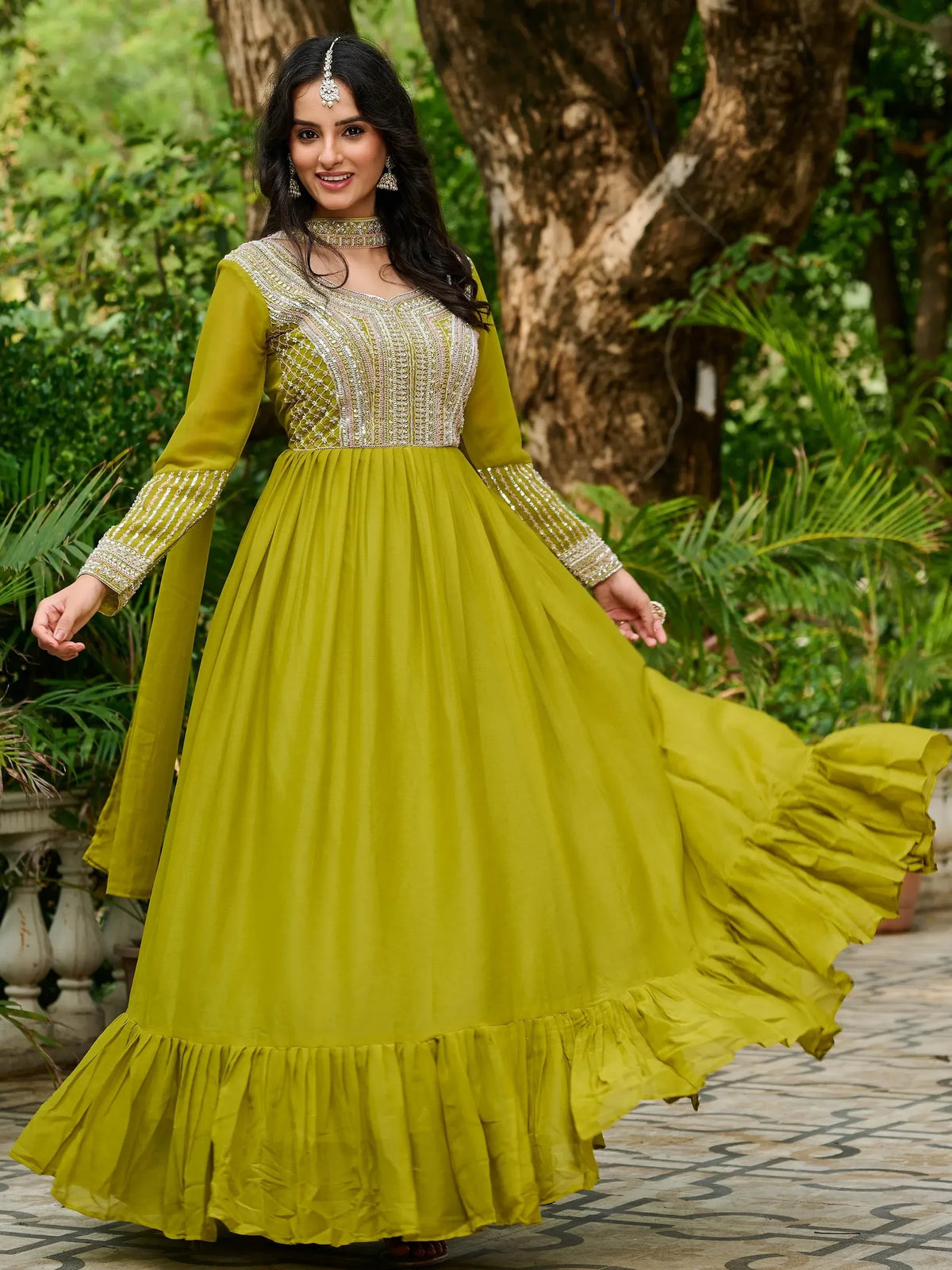 Woman in olive green ethnic gown with embroidery, perfect for Indian occasions and festive wear.
