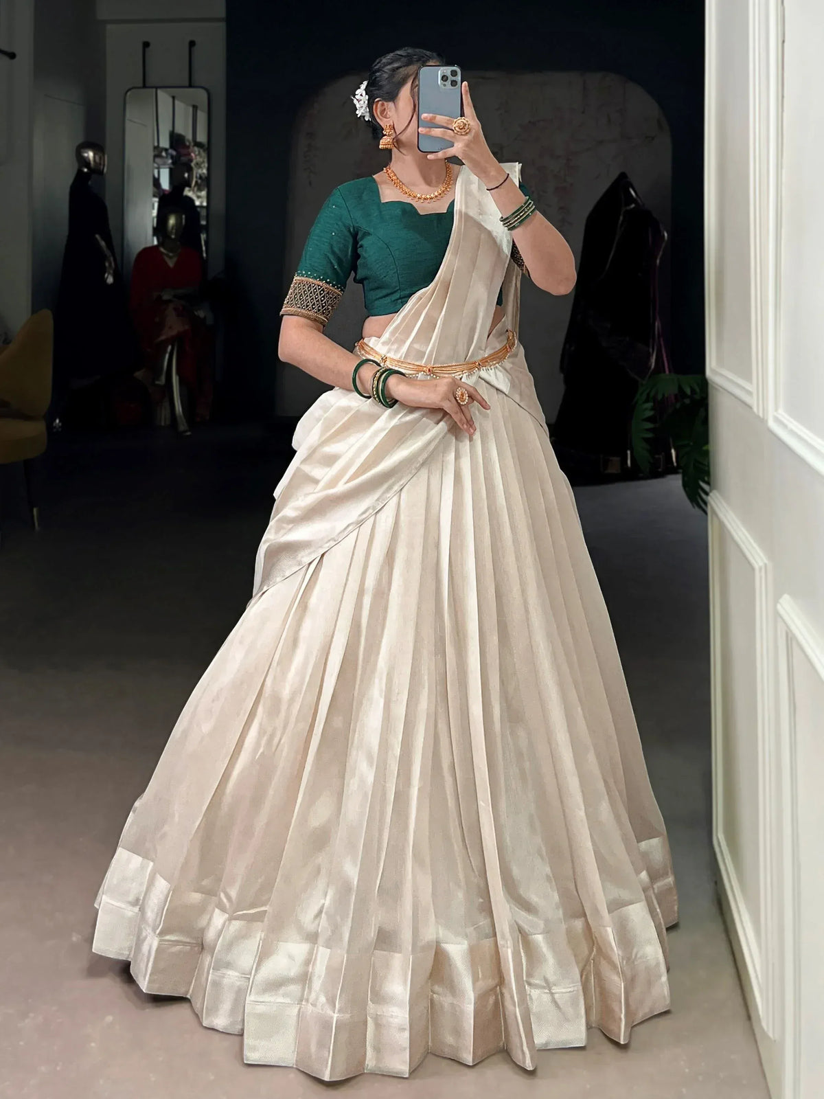 Woman in elegant ivory pleated saree with green blouse, gold jewelry, perfect for Indian ethnic occasions.