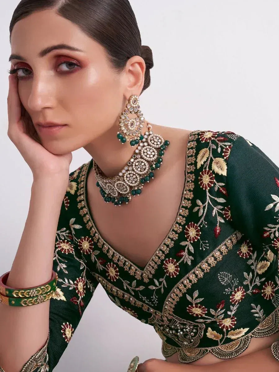Emerald green embroidered lehenga choli with gold floral detailing and matching jewelry set