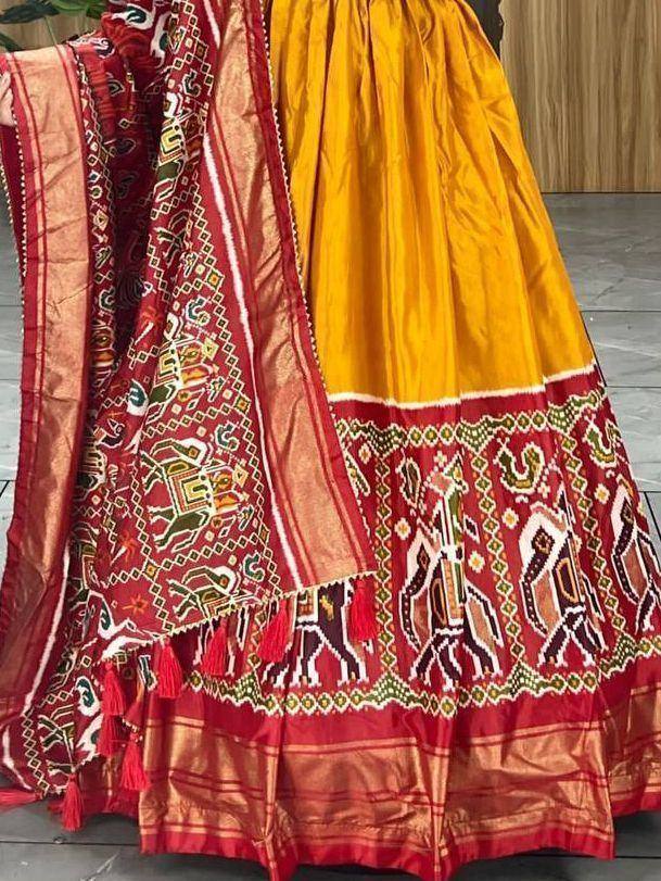 Yellow and red ethnic lehenga with intricate elephant embroidery and tassels, perfect for festive occasions.