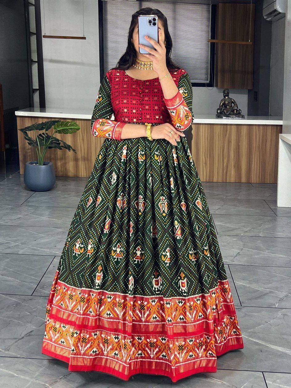 Woman in red and green printed ethnic anarkali gown with intricate patterns, perfect for festive occasions.