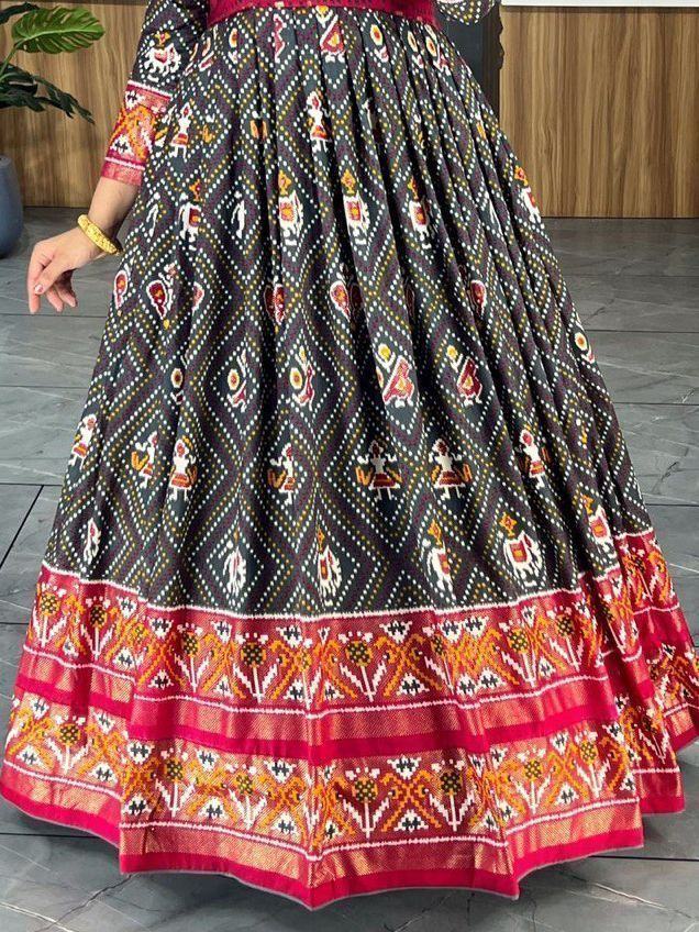 Black ethnic gown with colorful Ikat and folk motifs, detailed red and orange border.