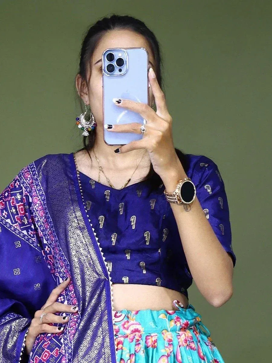 Woman in blue ethnic crop top with printed dupatta and floral skirt, taking mirror selfie