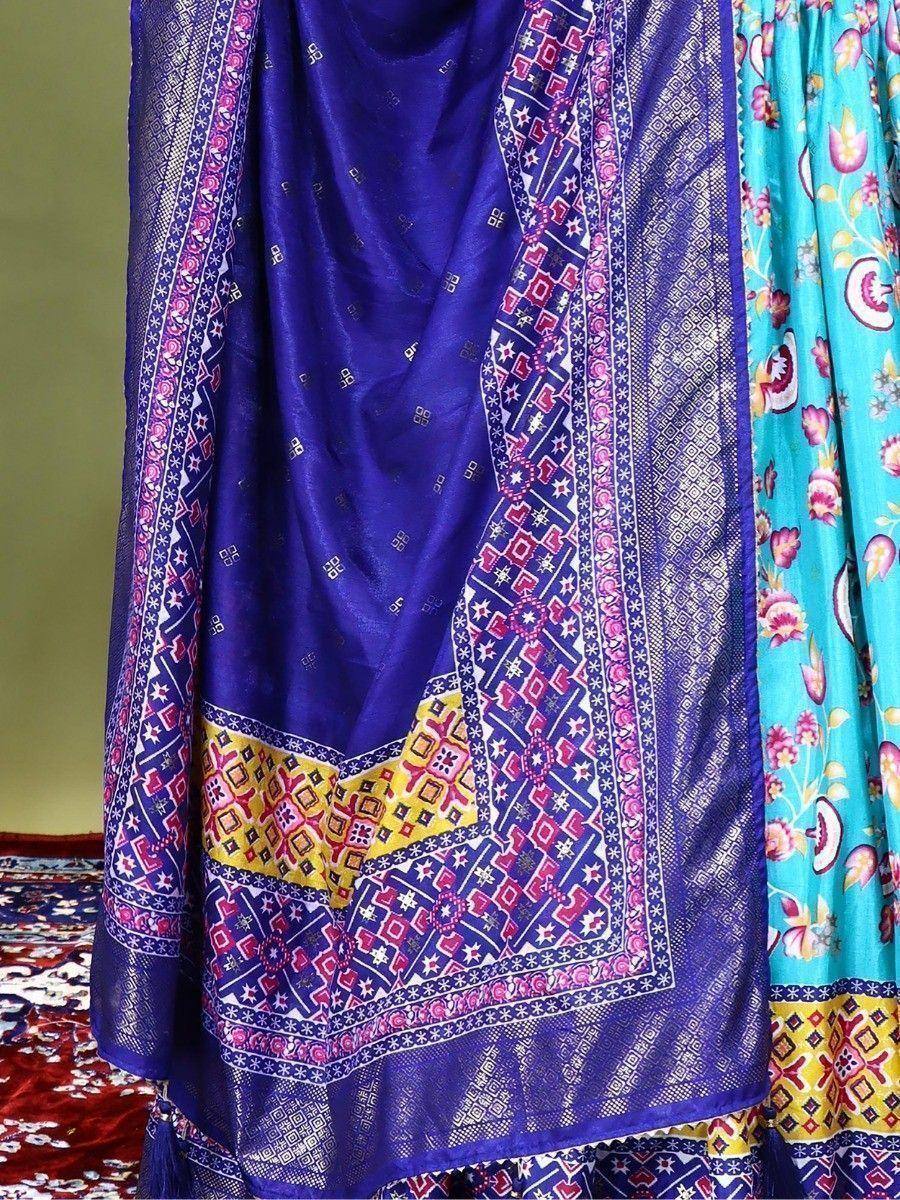 Vibrant purple and turquoise ethnic saree with intricate geometric and floral prints, perfect for Indian festive wear.