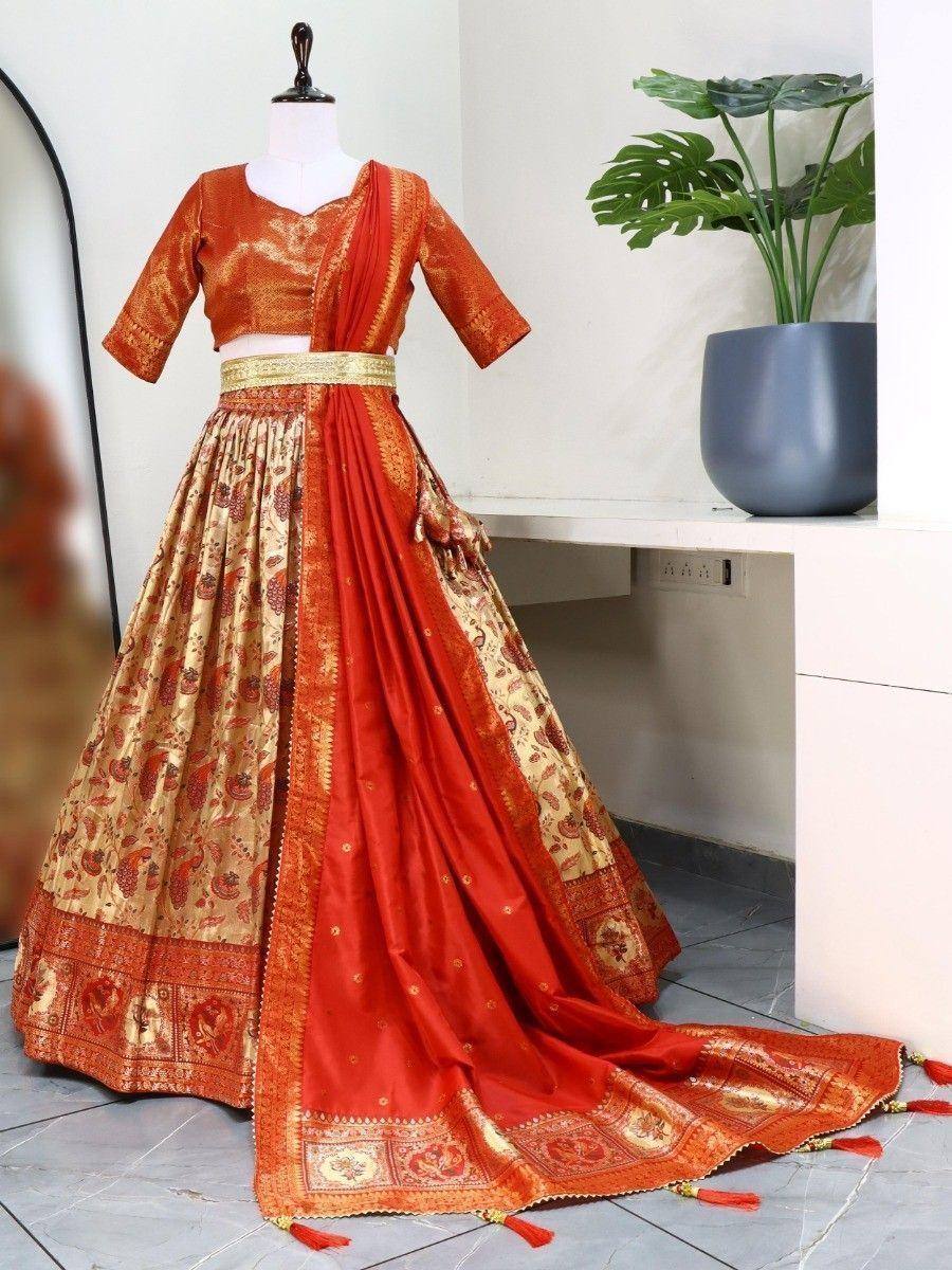 Orange and gold designer lehenga choli with intricate paisley print and tassel details, perfect for Indian ethnic wear.