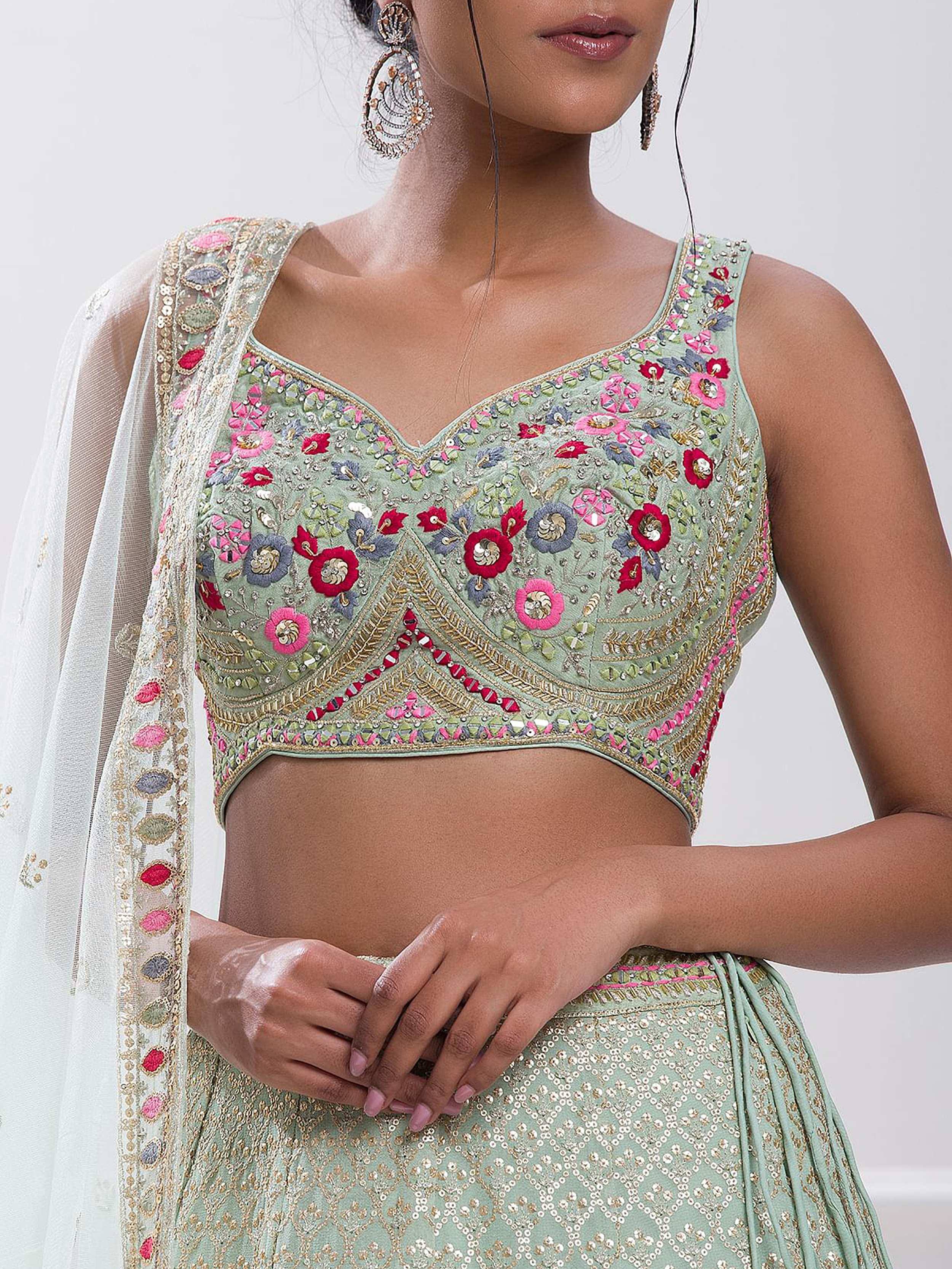 Mint green embroidered lehenga choli with floral motifs and sequin detailing, paired with sheer dupatta for Indian ethnic wear.