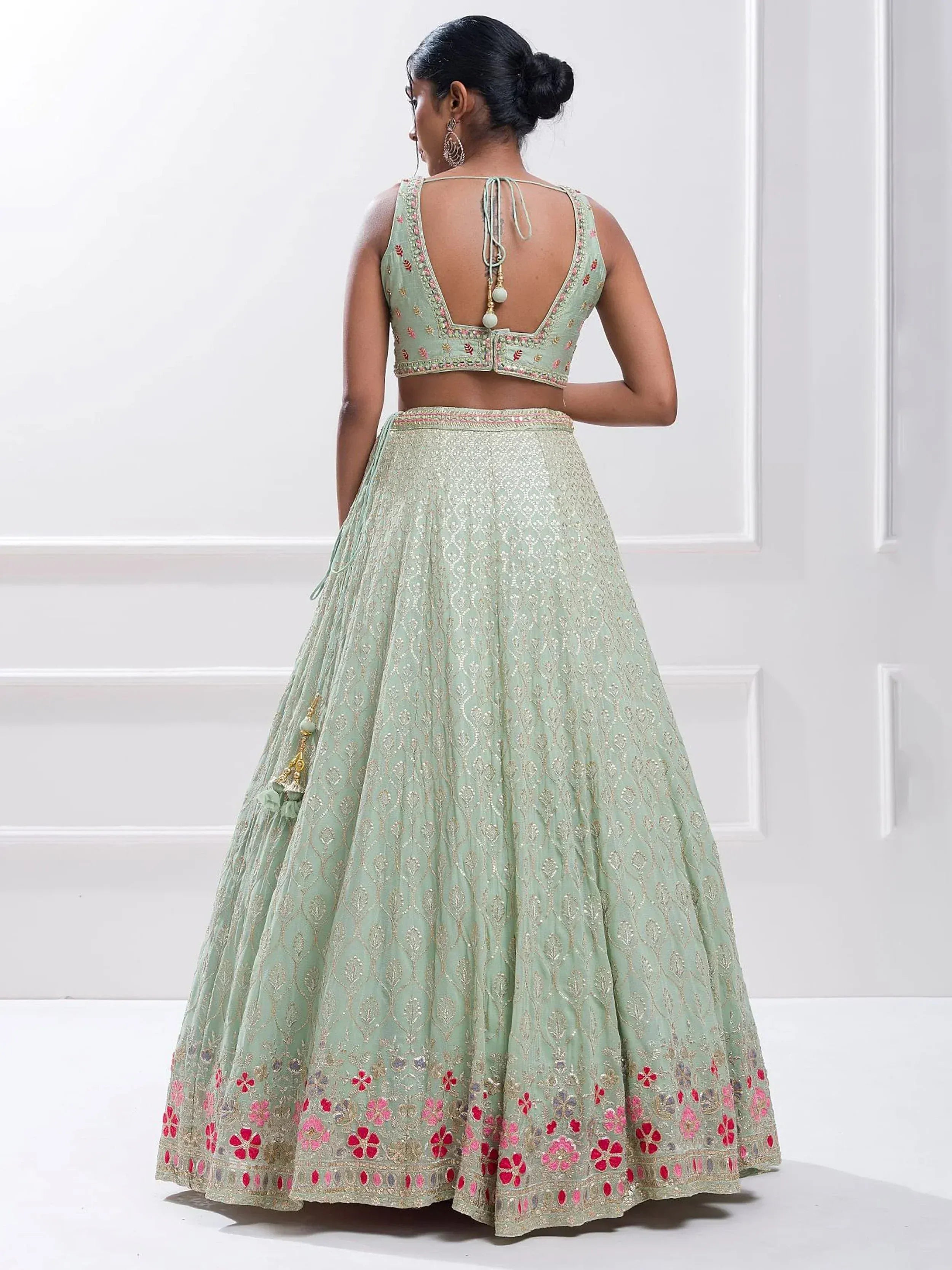 Mint green embroidered lehenga choli with floral motifs and back tie detail, perfect for Indian ethnic wear.