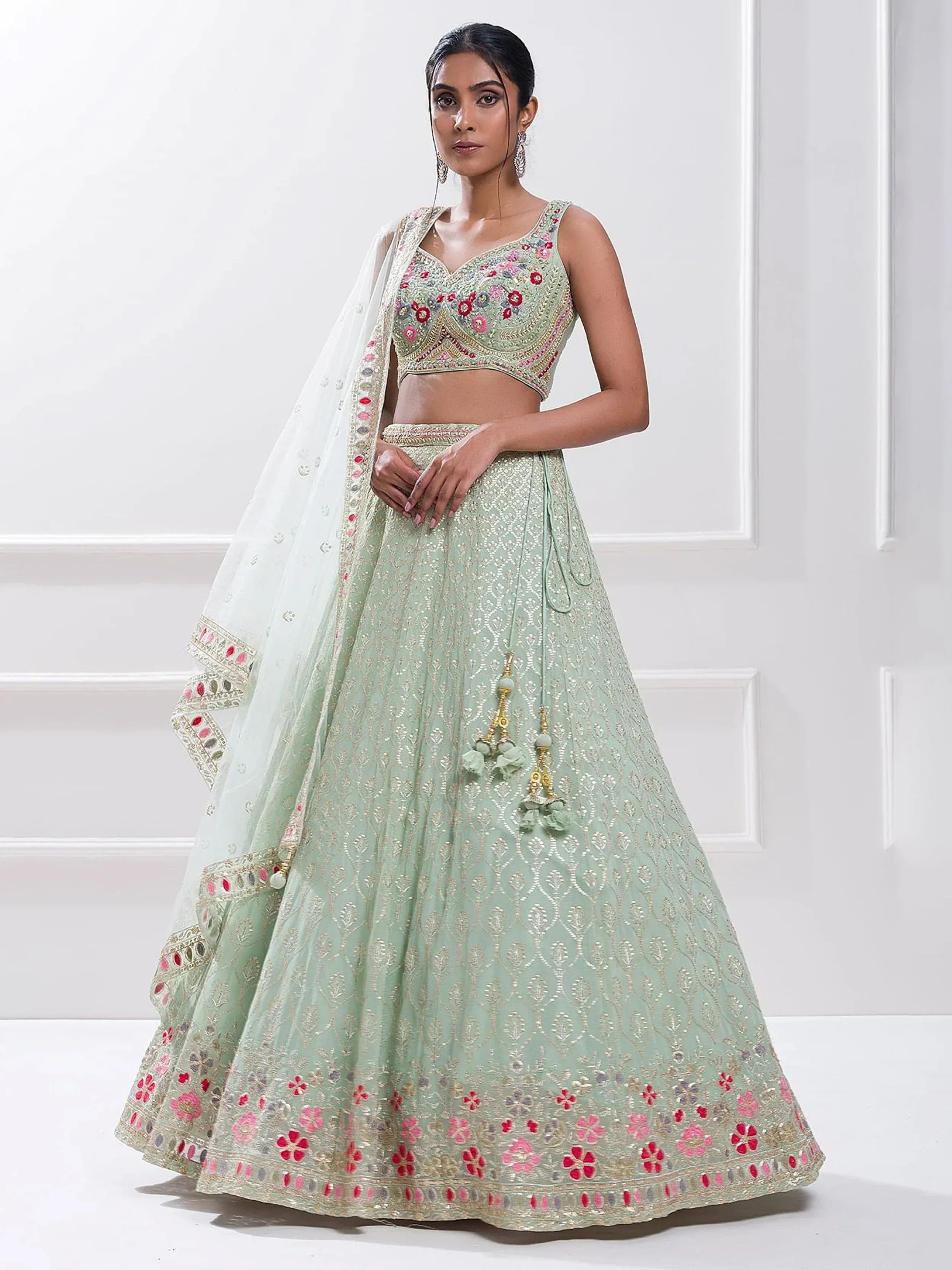Mint green embroidered lehenga choli with floral motifs and sheer dupatta, perfect for Indian ethnic wear occasions.