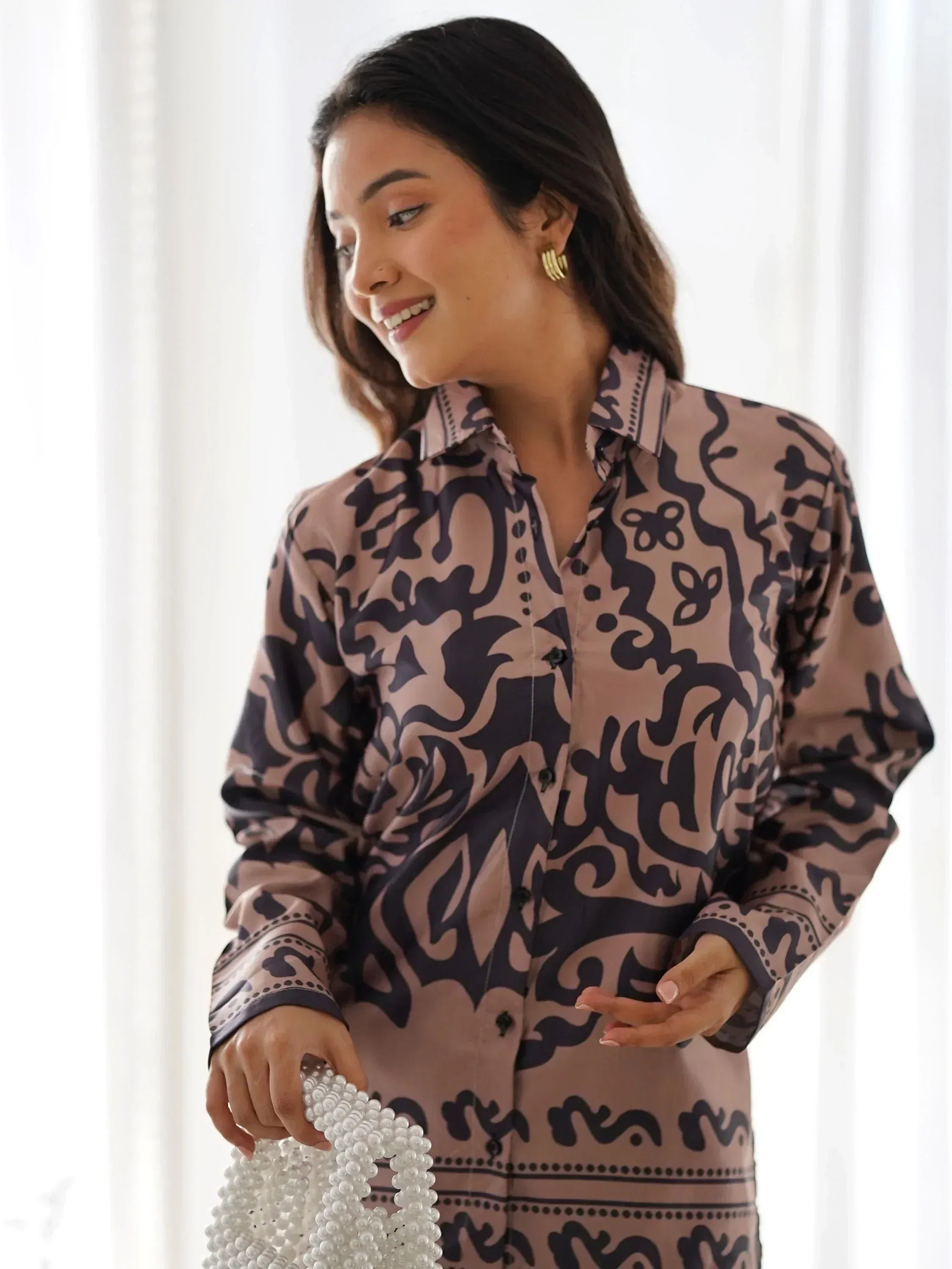 Woman in stylish printed shirt dress with pearl bag, perfect for ethnic fashion