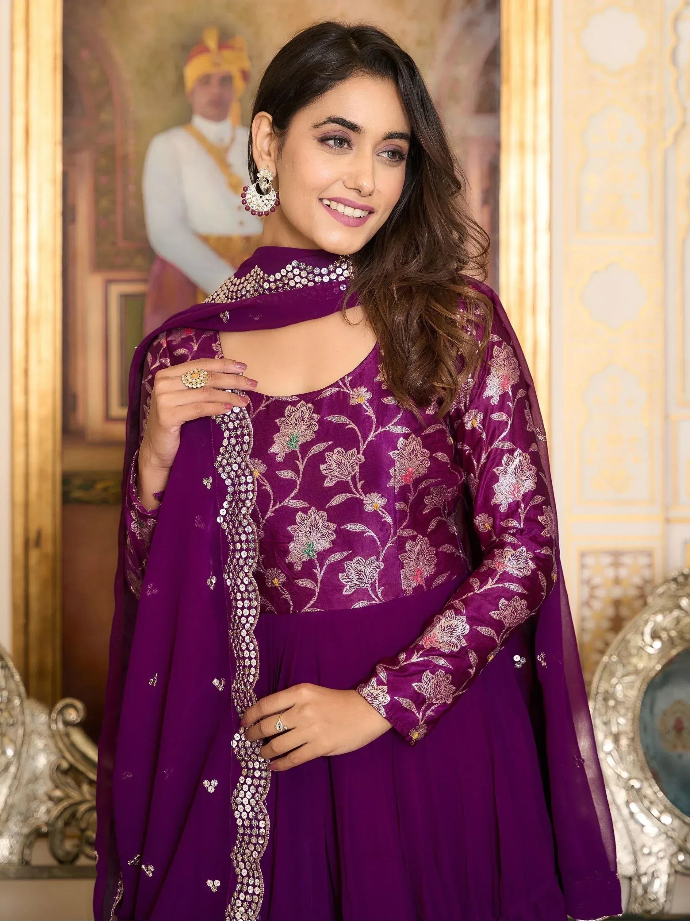 Woman wearing purple embroidered ethnic gown with dupatta, traditional Indian jewelry