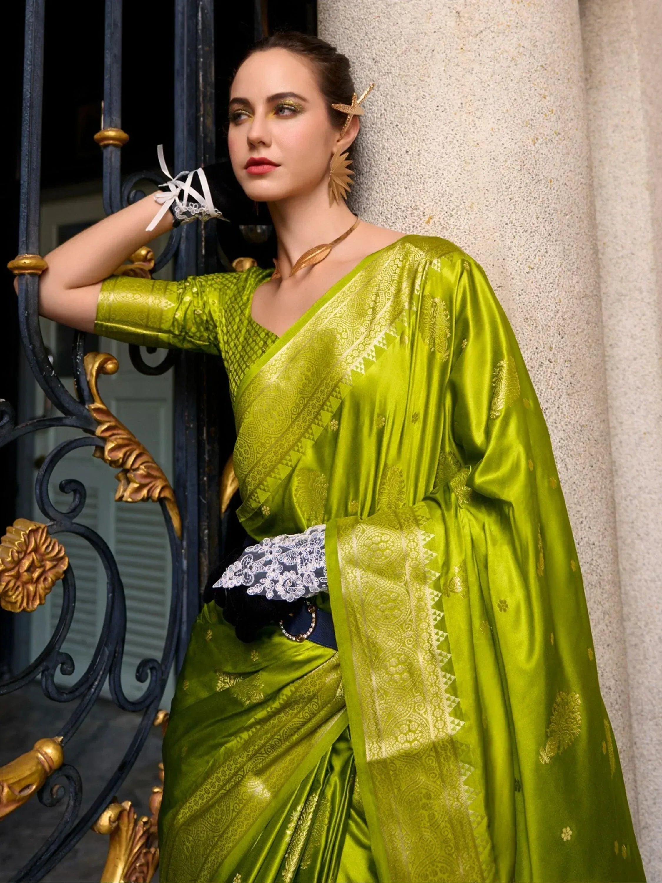 Vibrant green silk saree with gold zari work, paired with lace gloves and statement jewelry for ethnic wear.