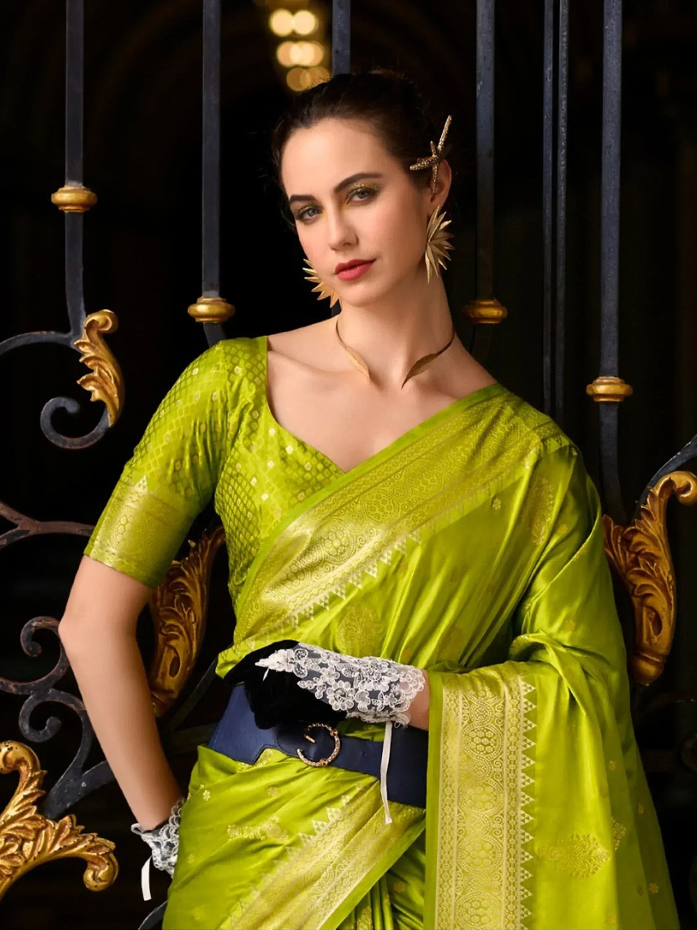 Vibrant green designer saree with gold patterns, lace gloves, and statement jewelry for ethnic wear