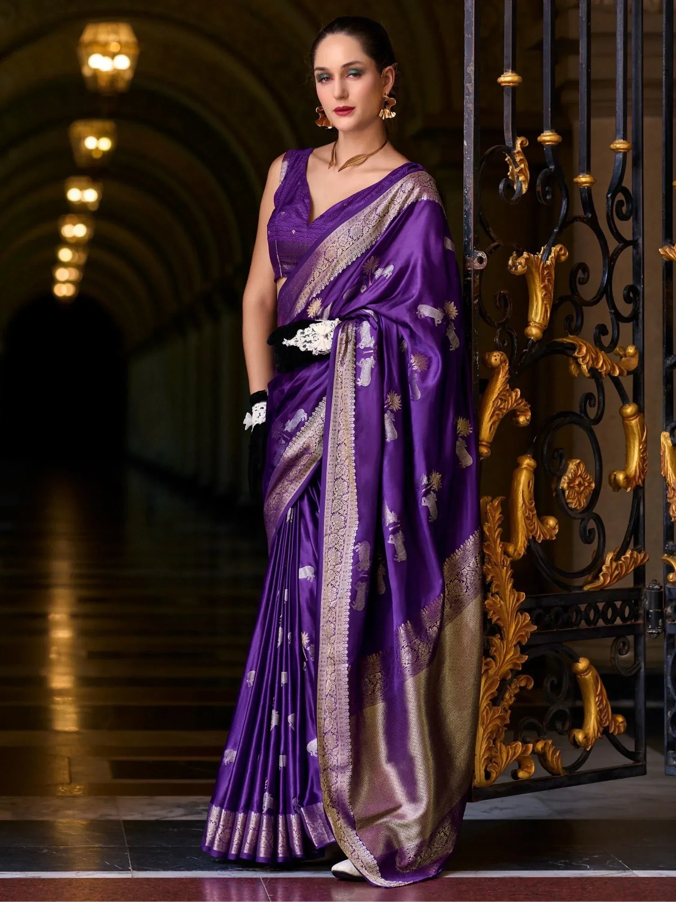 Purple silk saree with gold elephant motifs and zari border, styled with black lace gloves for ethnic wear.
