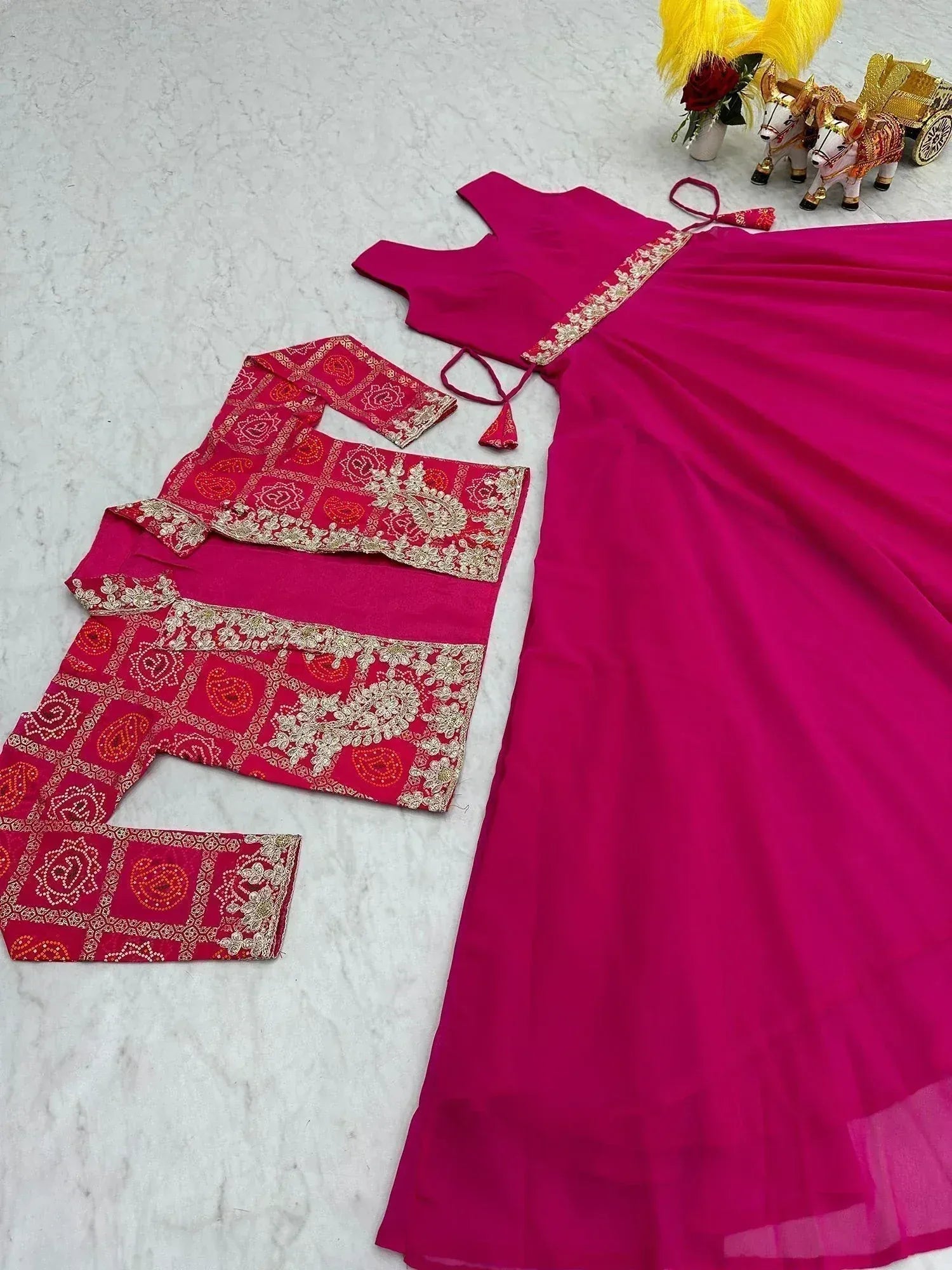 Fuchsia pink ethnic gown with red embroidered dupatta, perfect for Indian weddings and festive occasions.