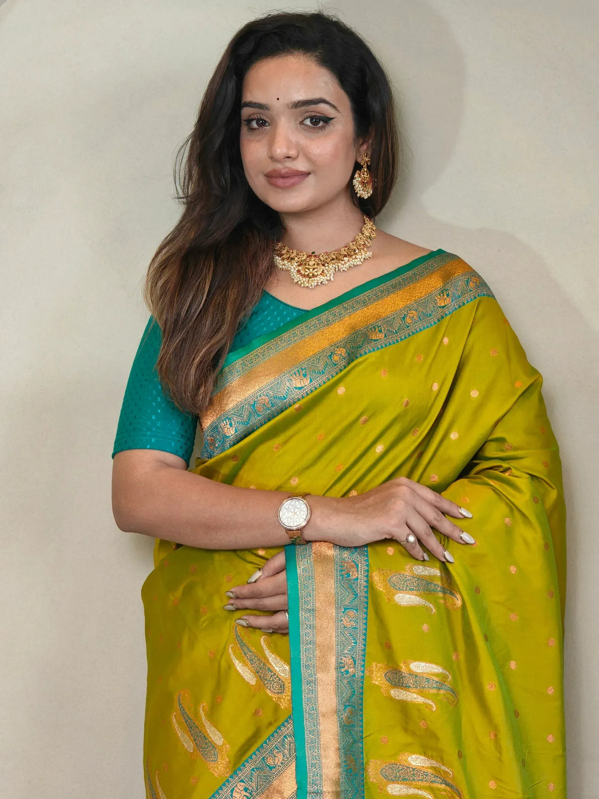 Woman in vibrant green and yellow designer saree with gold embroidery, perfect for Indian ethnic wear occasions