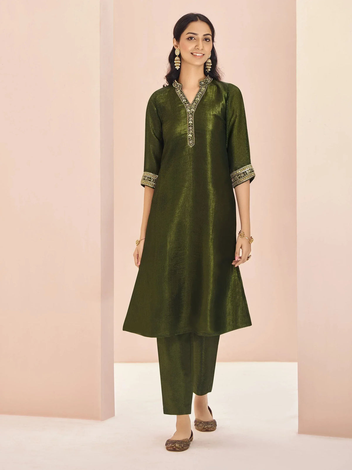 Olive green ethnic kurta with gold embroidery, paired with matching pants and juttis, perfect for Indian occasions.