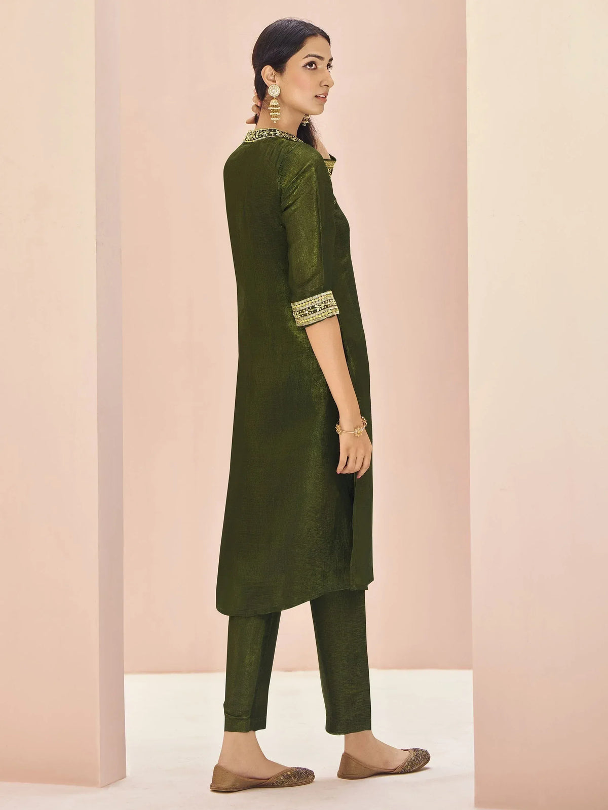 Olive green ethnic kurta with gold embroidery, paired with matching pants and juttis, styled for Indian wear.