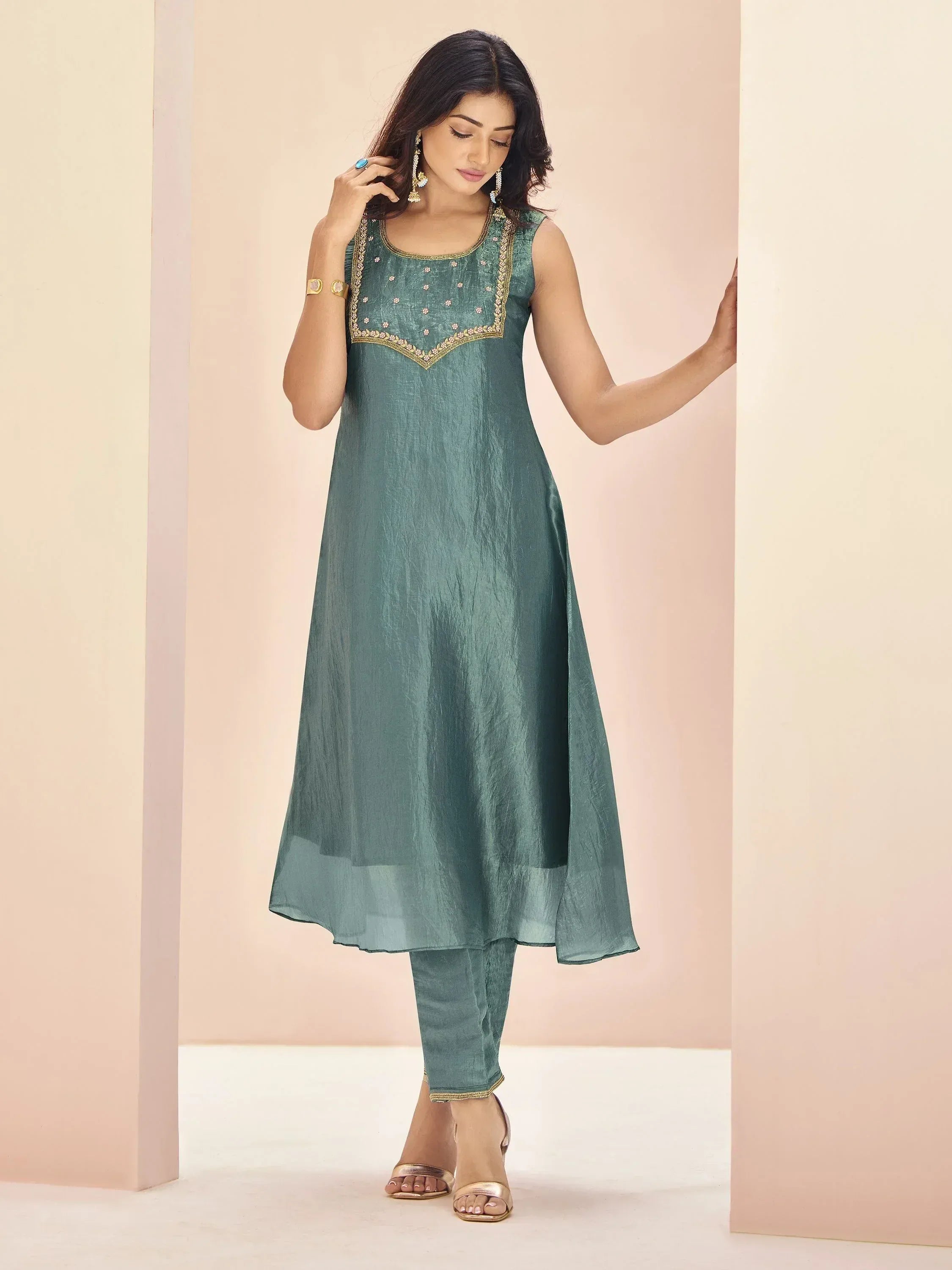Teal green sleeveless ethnic kurta with gold embroidery and matching pants, styled for Indian wear