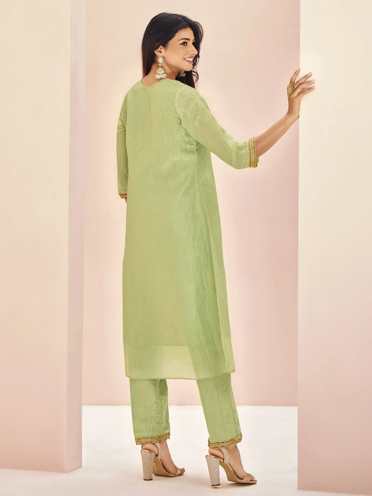 Light green ethnic kurta with gold trim paired with matching pants, styled for festive occasions.