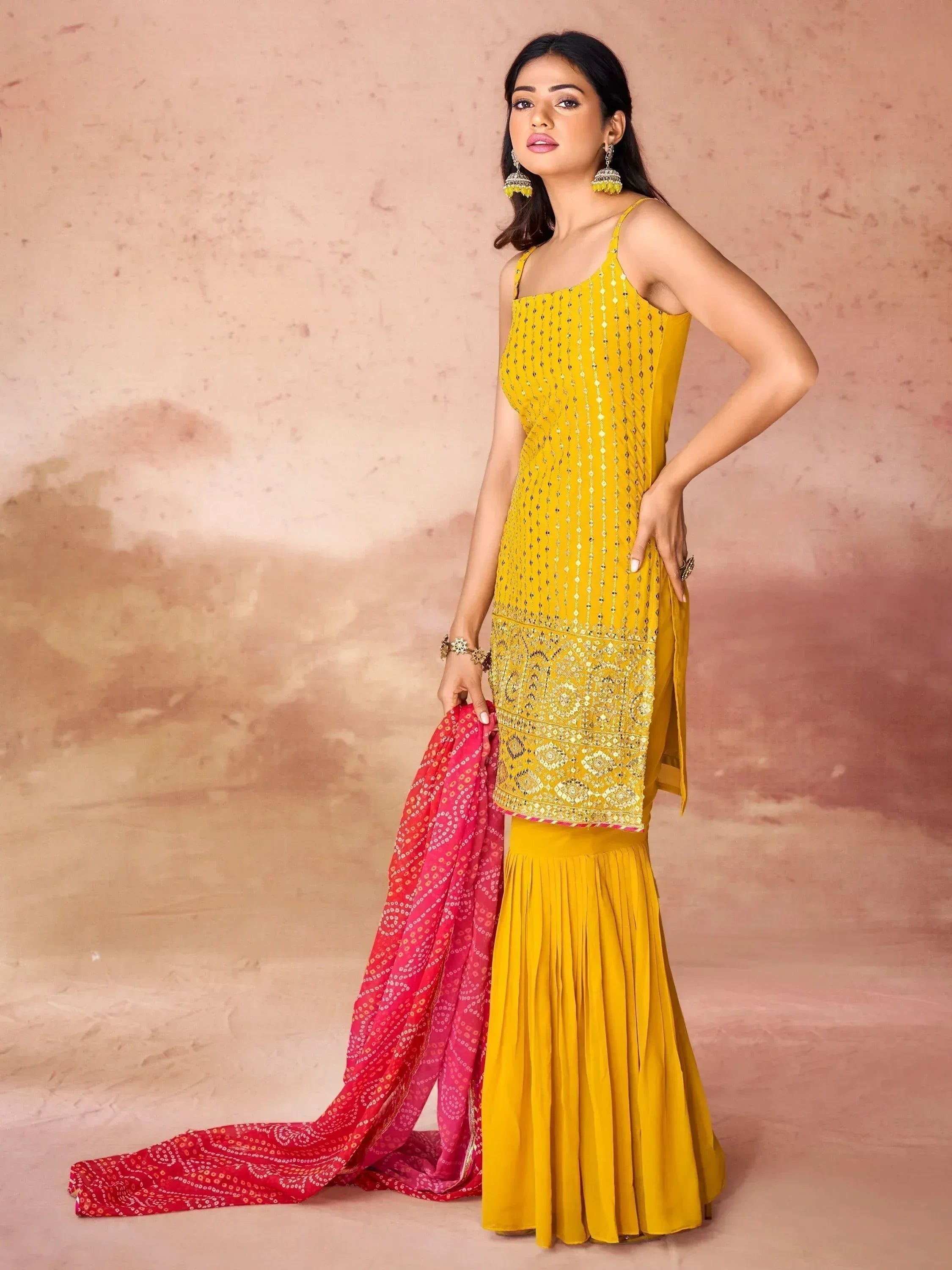 Yellow embroidered ethnic gown with pleated skirt and pink dupatta, perfect for Indian festive occasions