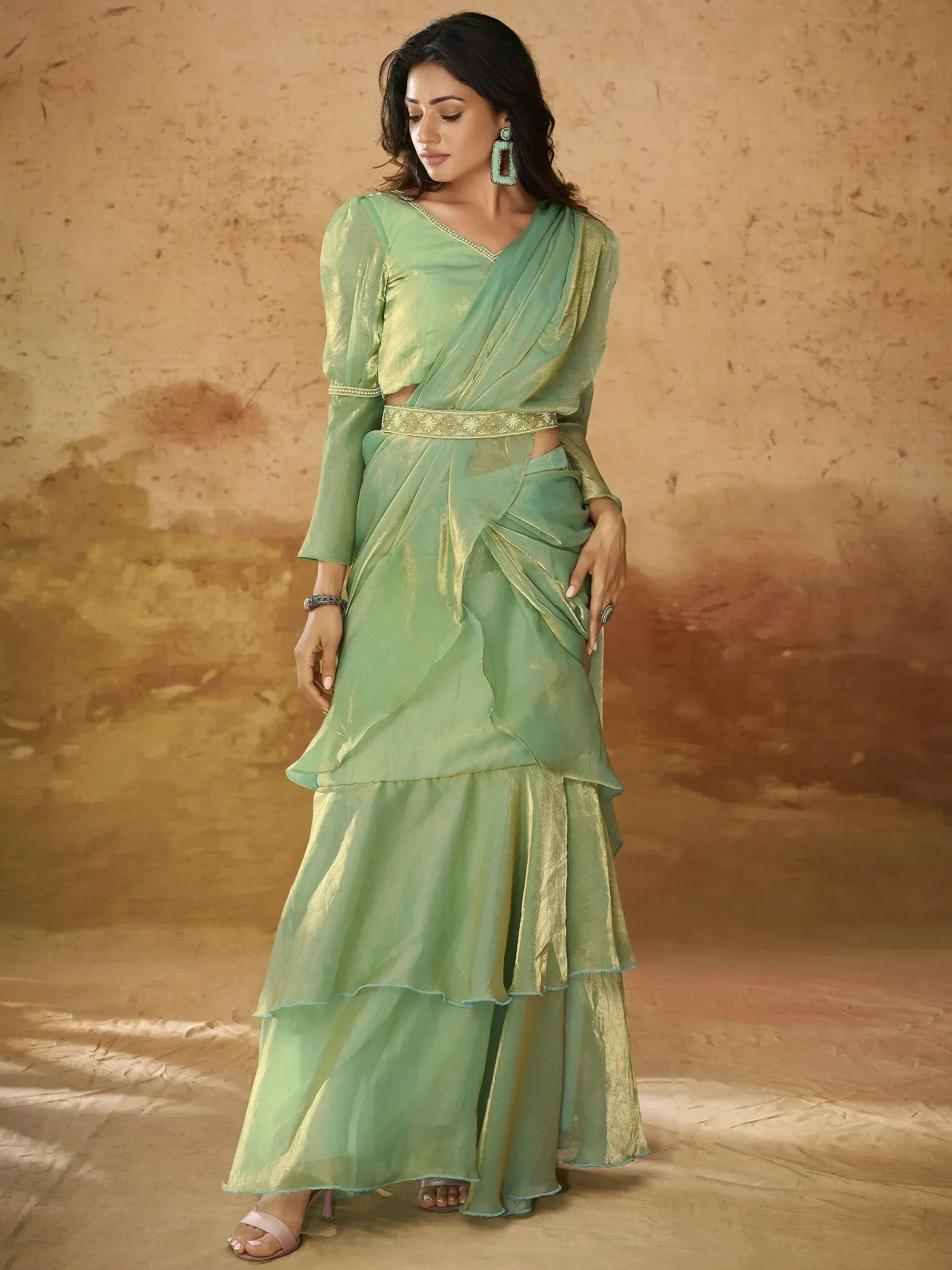 Mint green ethnic gown with ruffled layers and gold trim, perfect for Indian festive occasions