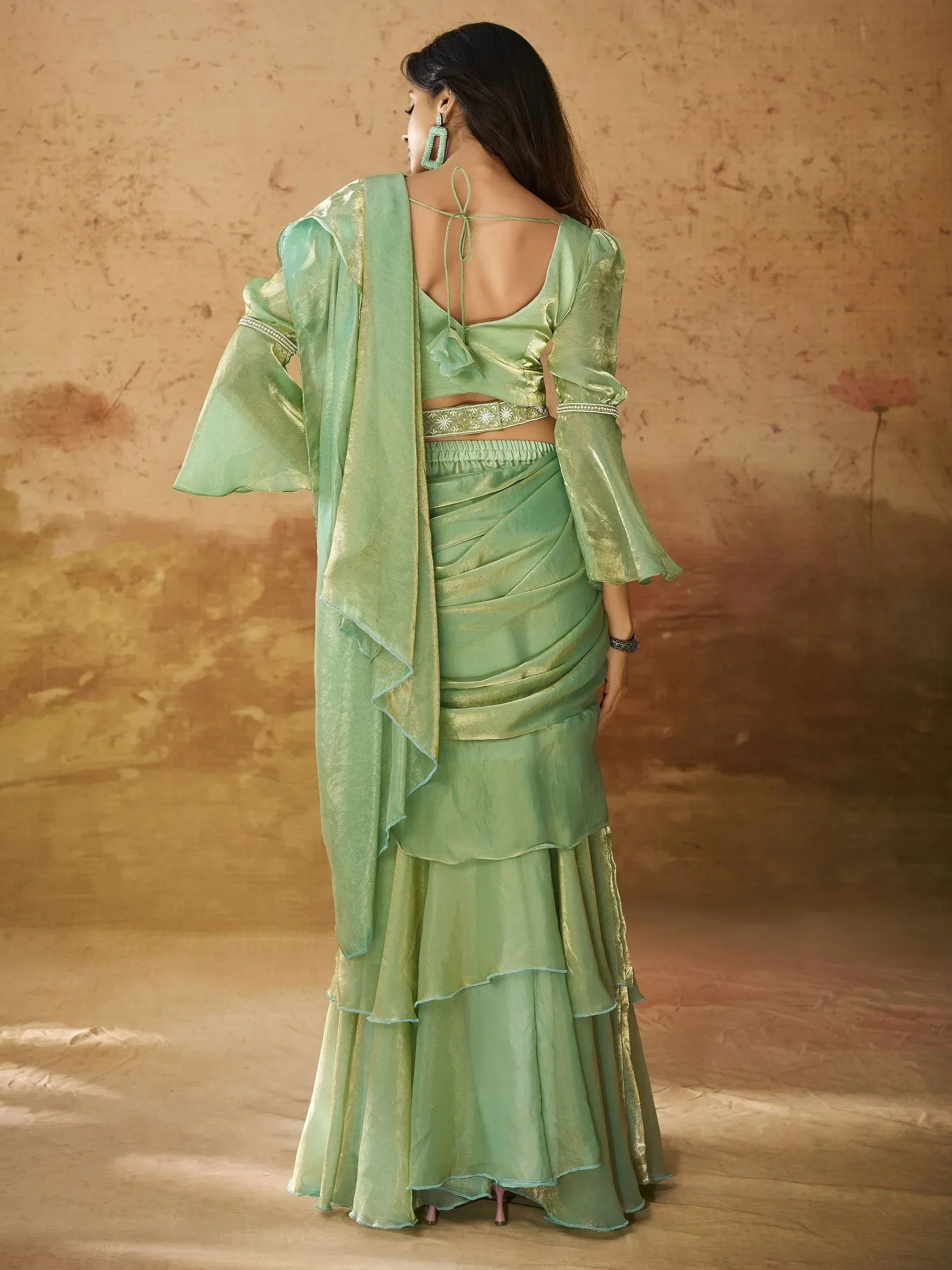 Mint green ethnic gown with ruffled layers, bell sleeves, and back tie detail for festive occasions