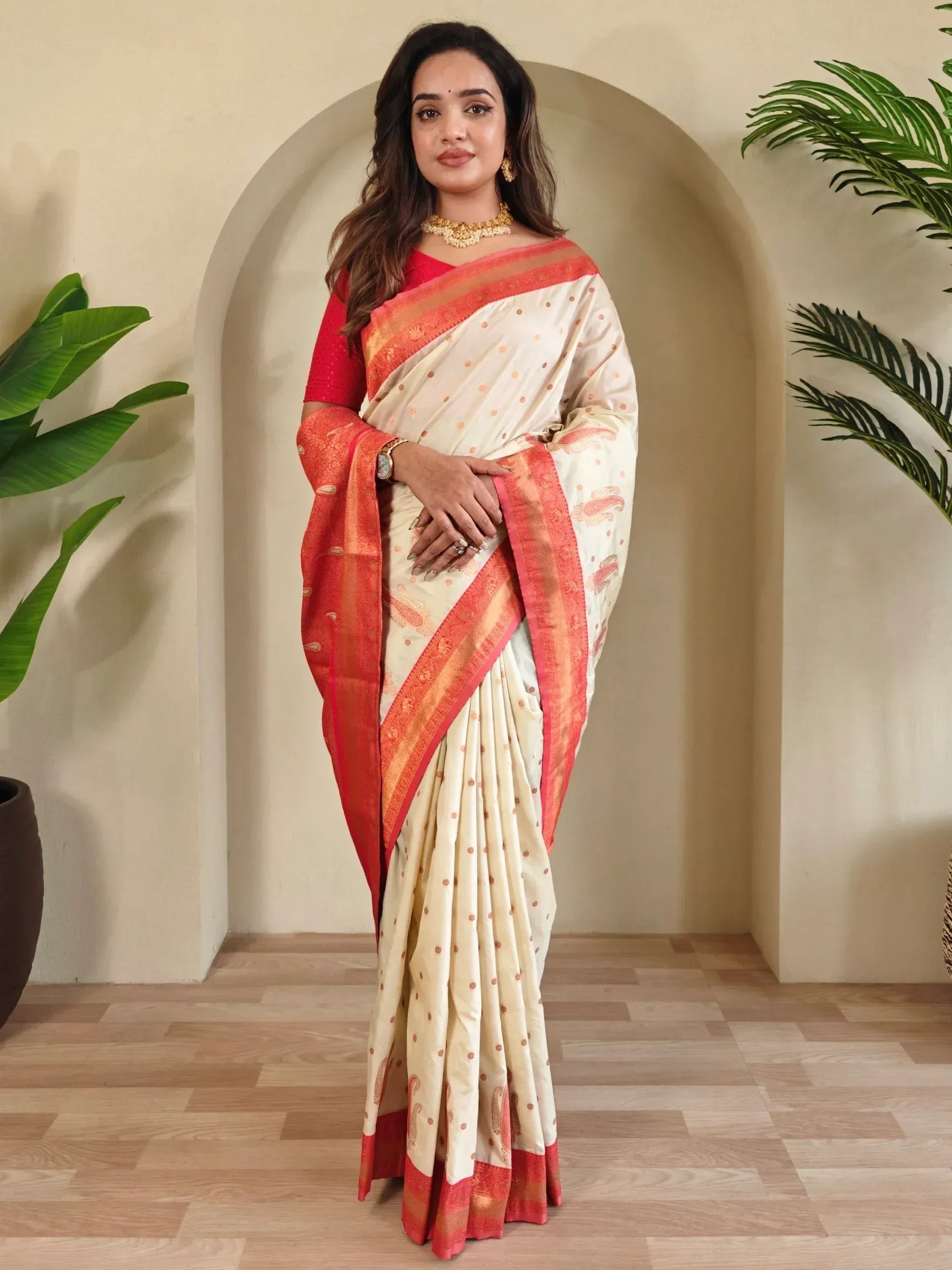 Cream and red ethnic saree with gold polka dots and border, paired with red blouse, perfect for Indian occasions.