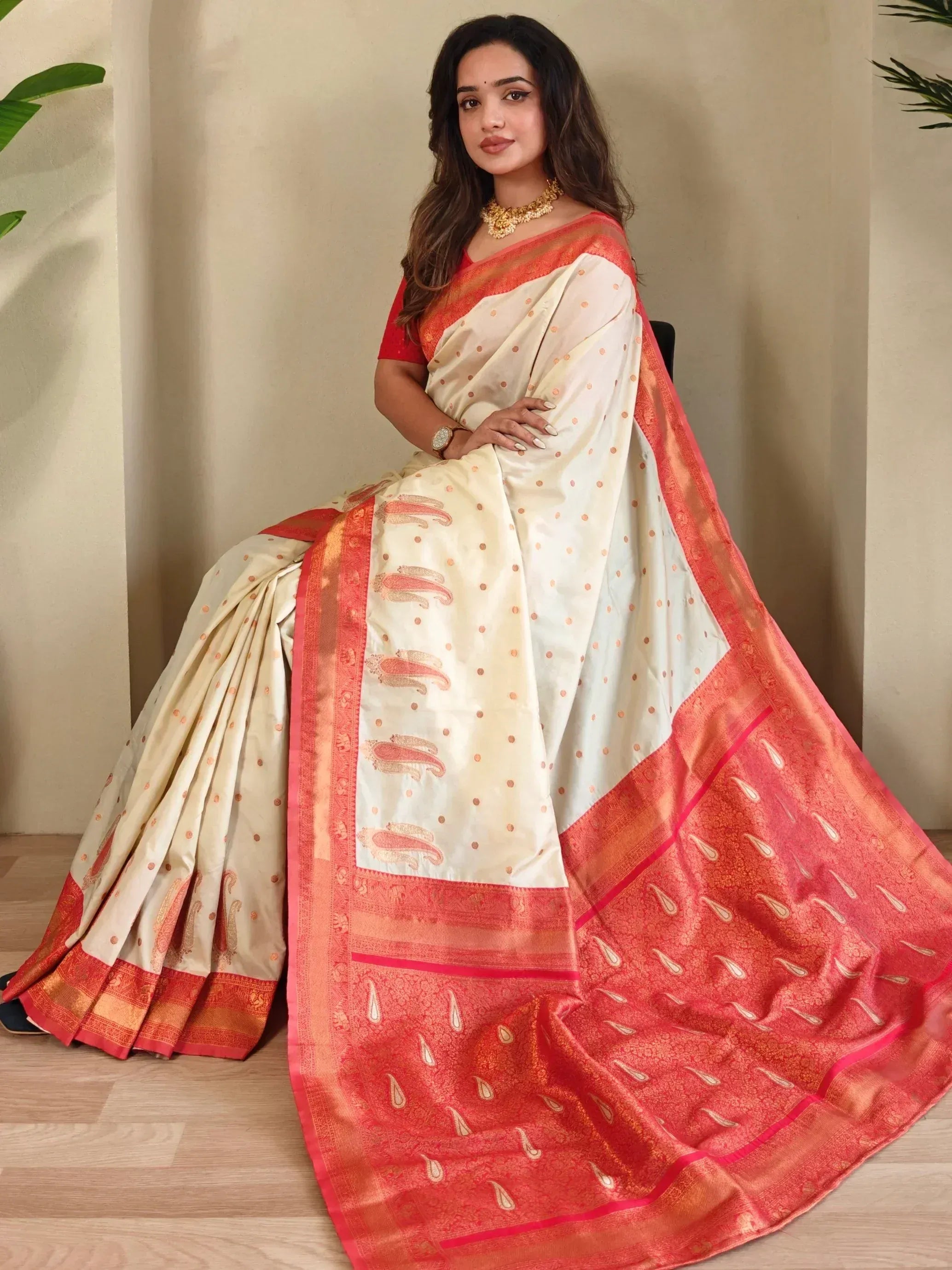 Cream and coral designer saree with paisley print and gold border, perfect for ethnic occasions