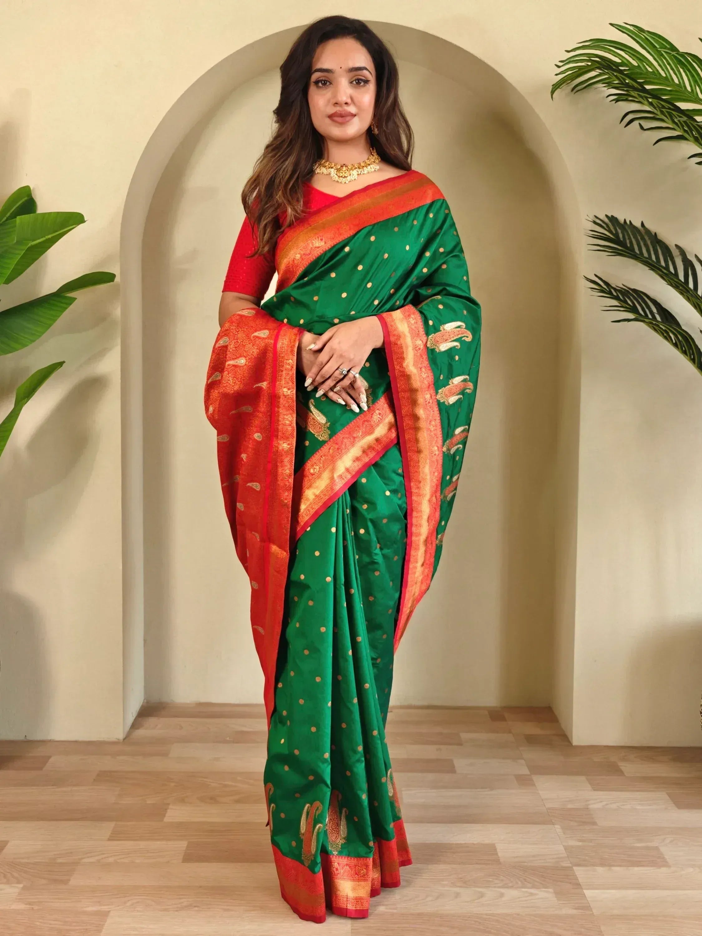 Green and red ethnic saree with gold polka dots and paisley border, perfect for Indian occasions