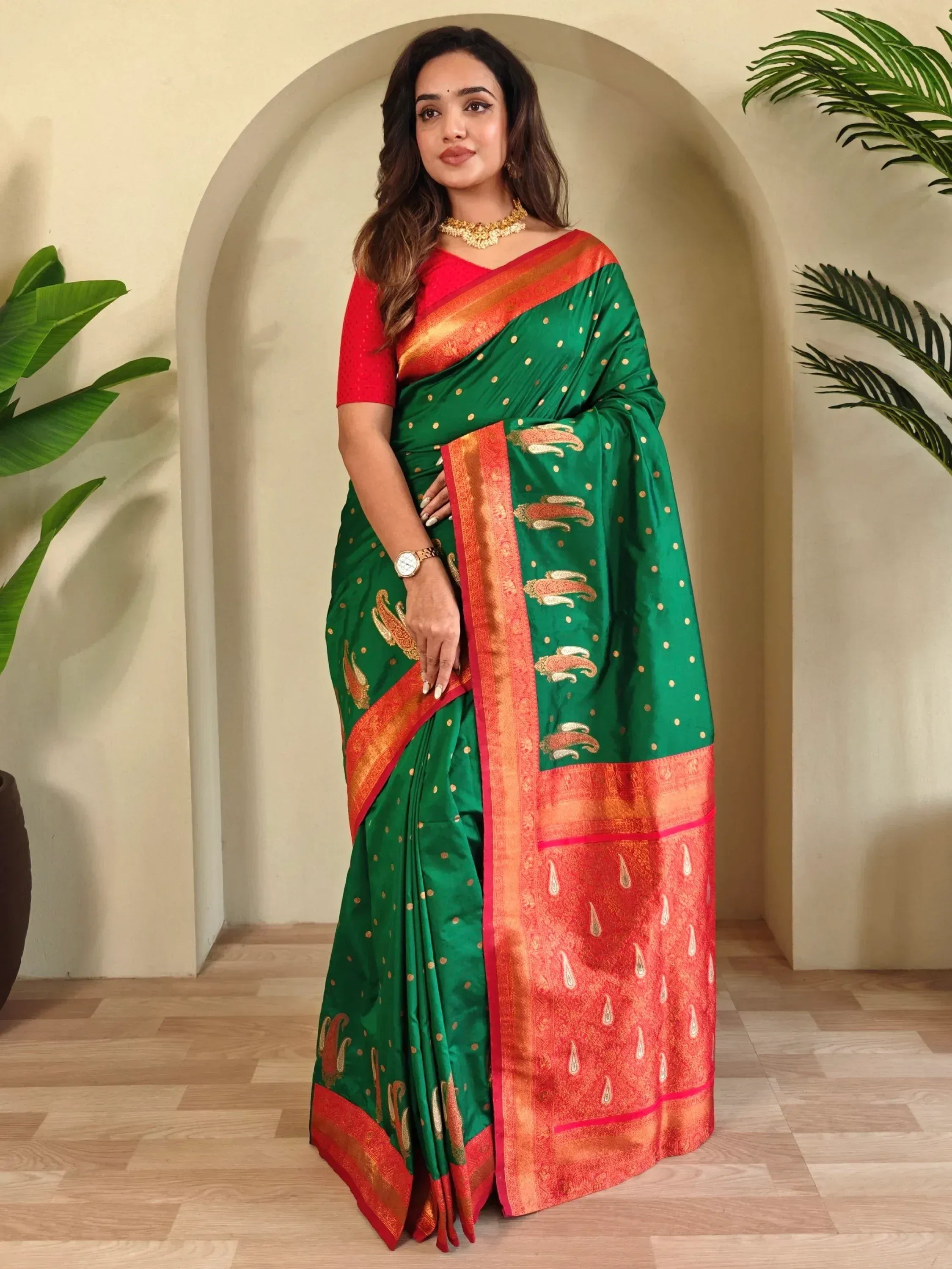 Green and red designer saree with gold paisley motifs and border, paired with matching blouse for ethnic wear